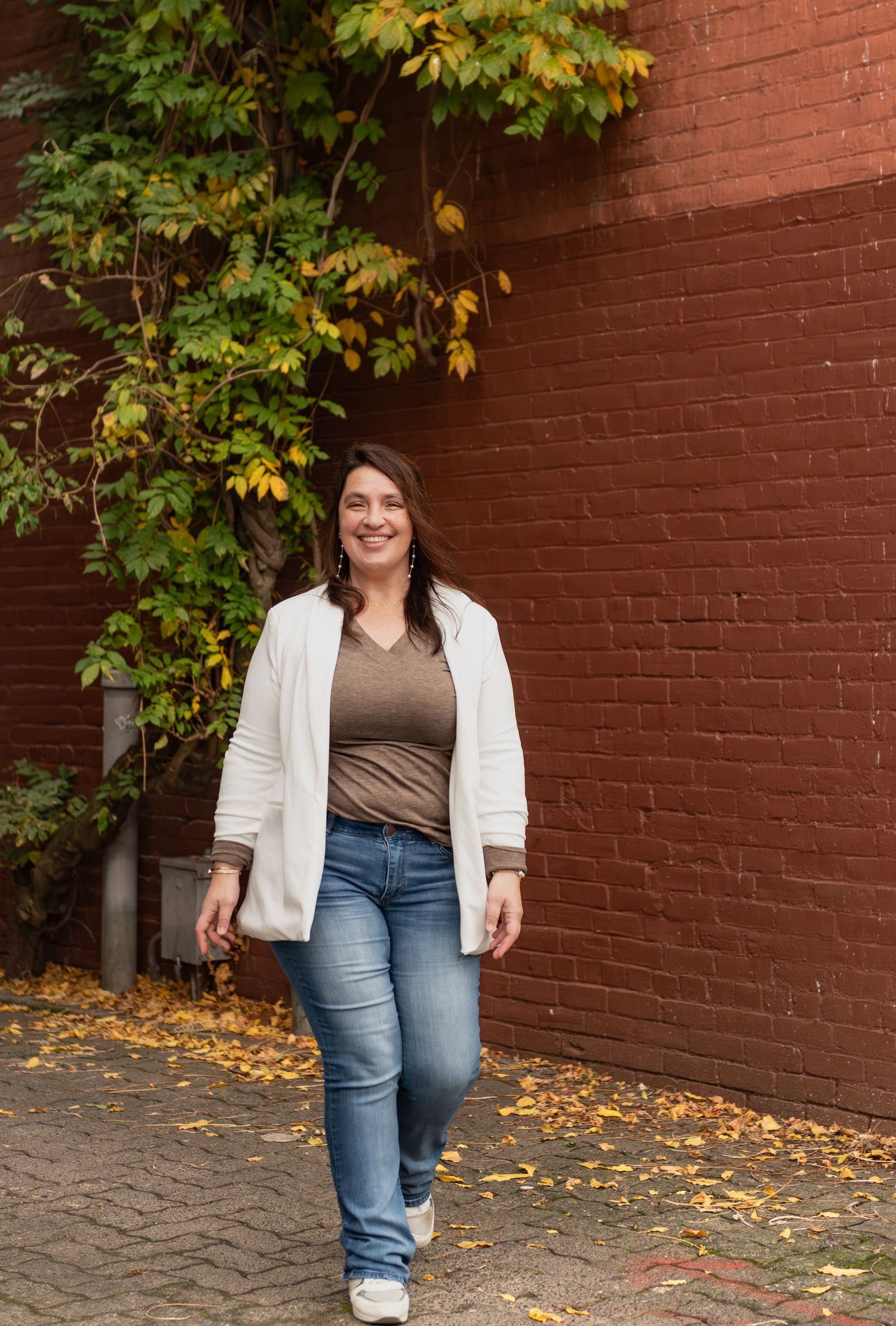 Headshot of woman on steps with red brick background, for branding images, located in Salem, OR.