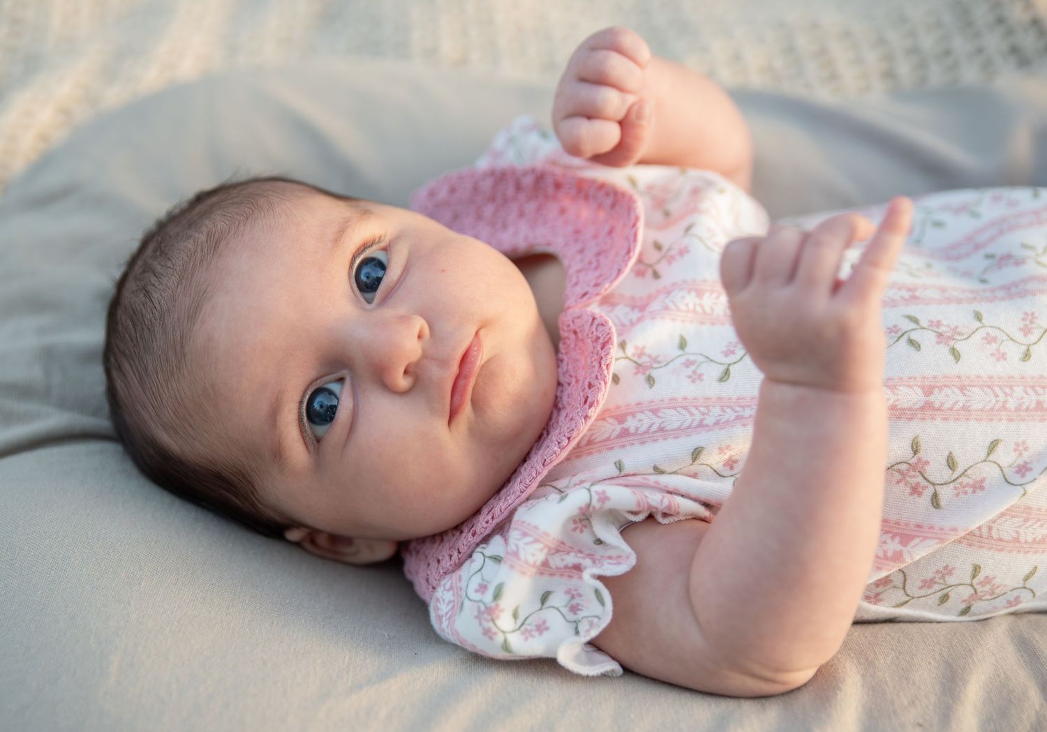 four month old baby laying in a lounger for a portrait photo with soft glowing golden hour light, Salem, OR.