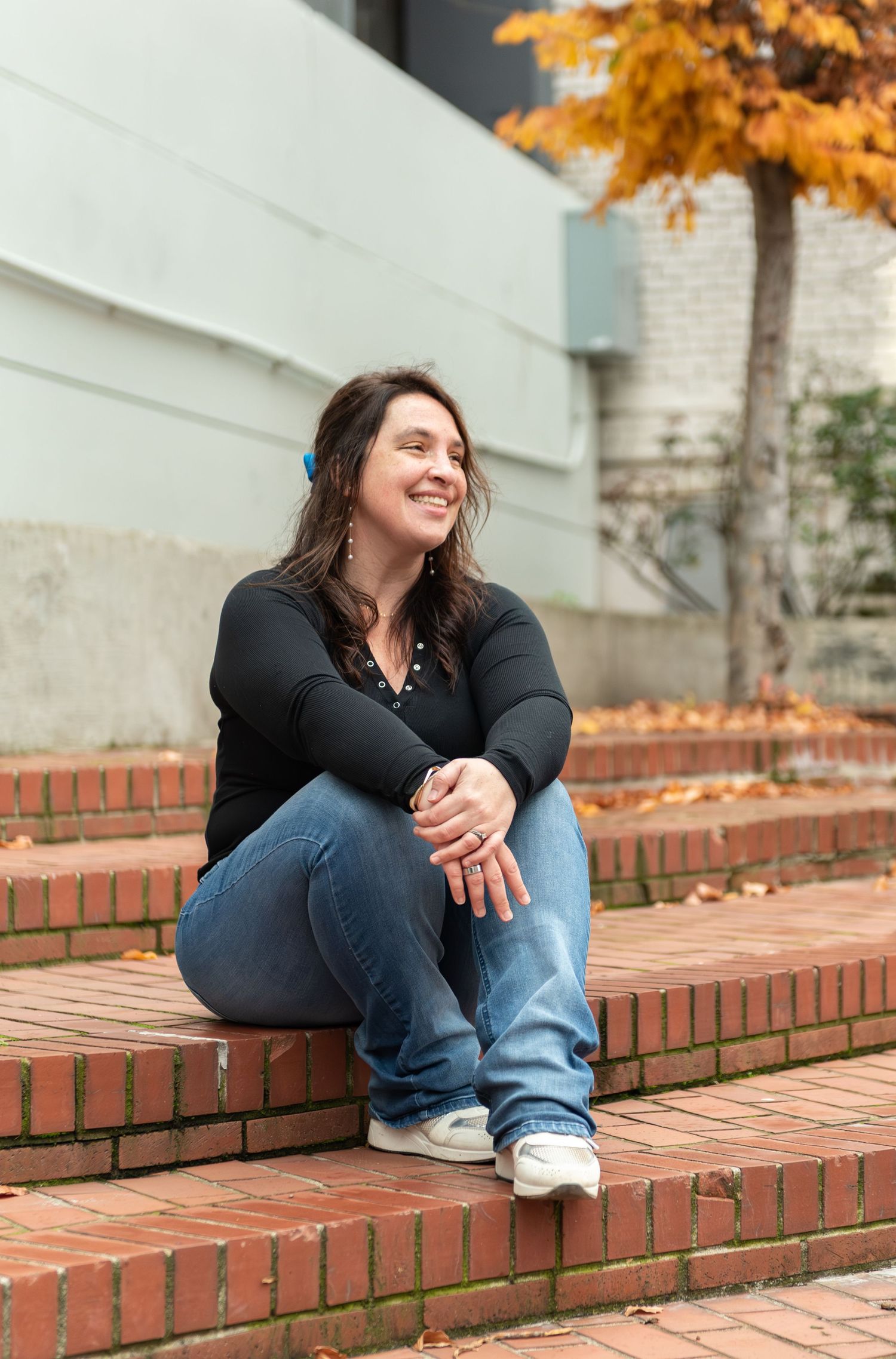 Headshot of woman on steps with red brick background, for branding images, located in Salem, OR.