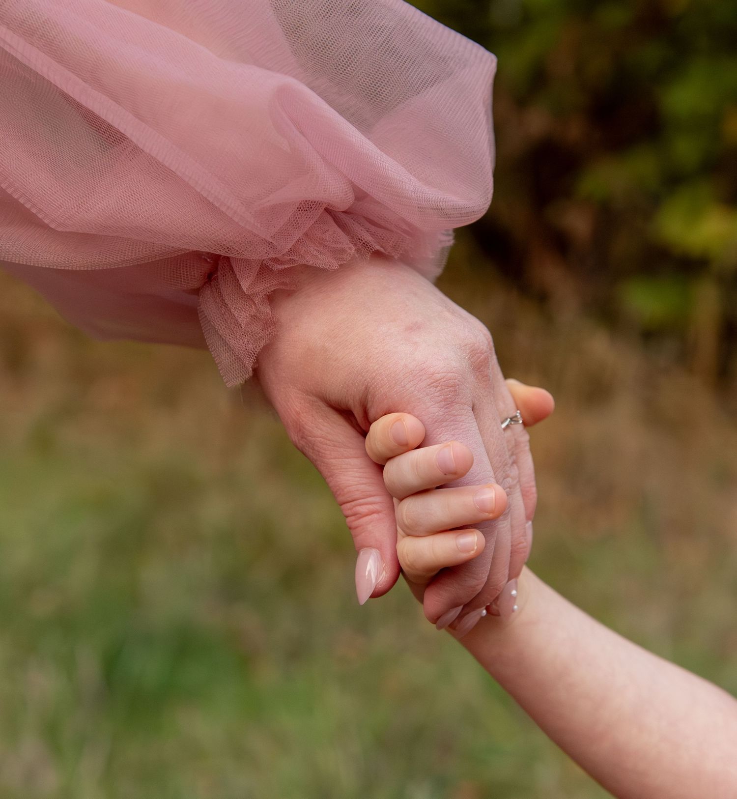 detailed image of Young boy holding moms hand located in an open field in Salem, OR