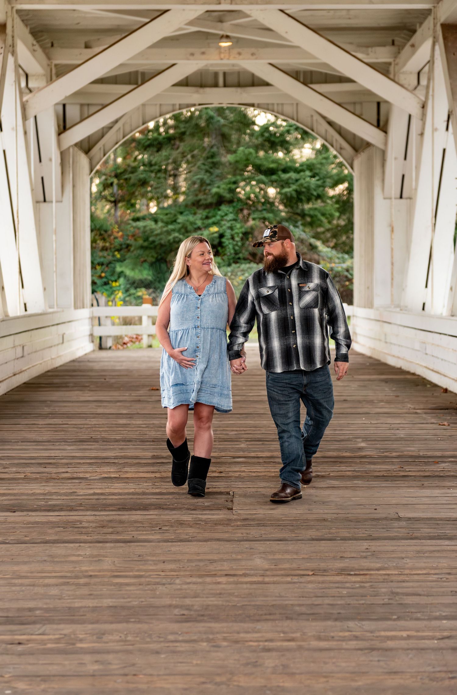 Detailed maternity image of mom and dad walking through a covered bridge Stayton, OR
