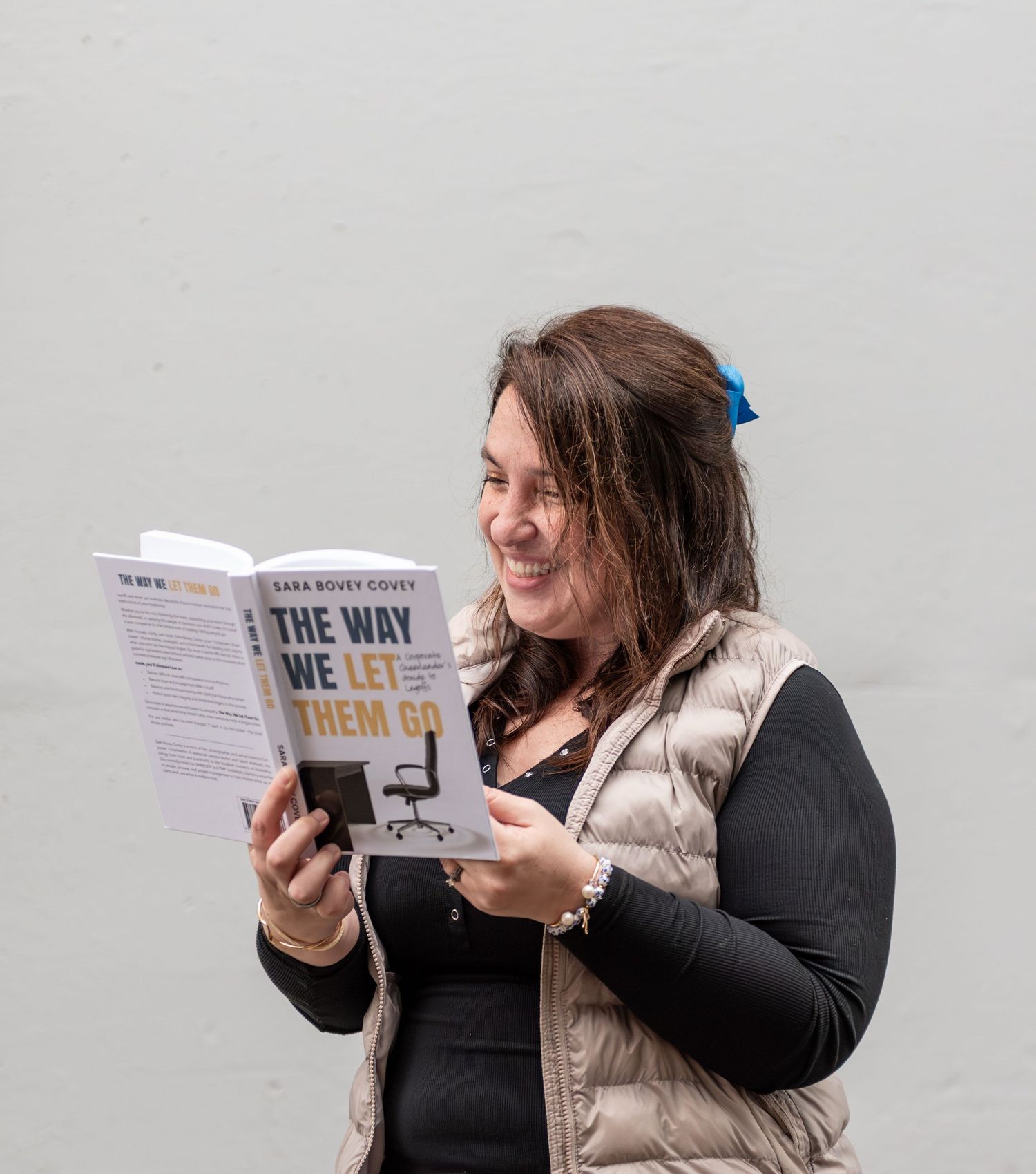 Author reading her book while posed on a sidewalk with a Neutral  background. Downtown Salem, OR.