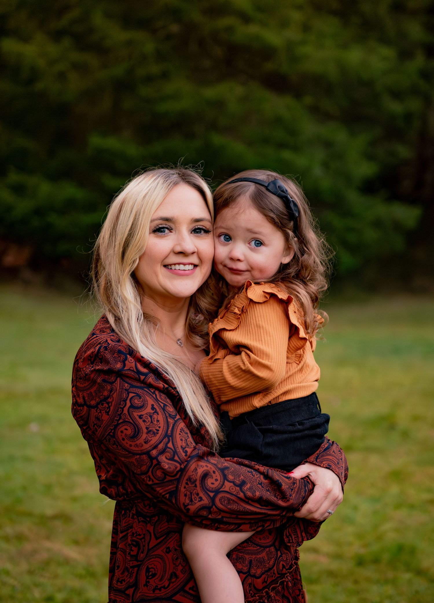 Mother and daughter share tender moments outdoors during autumn photo session in a park setting. Silver Falls State Park OR