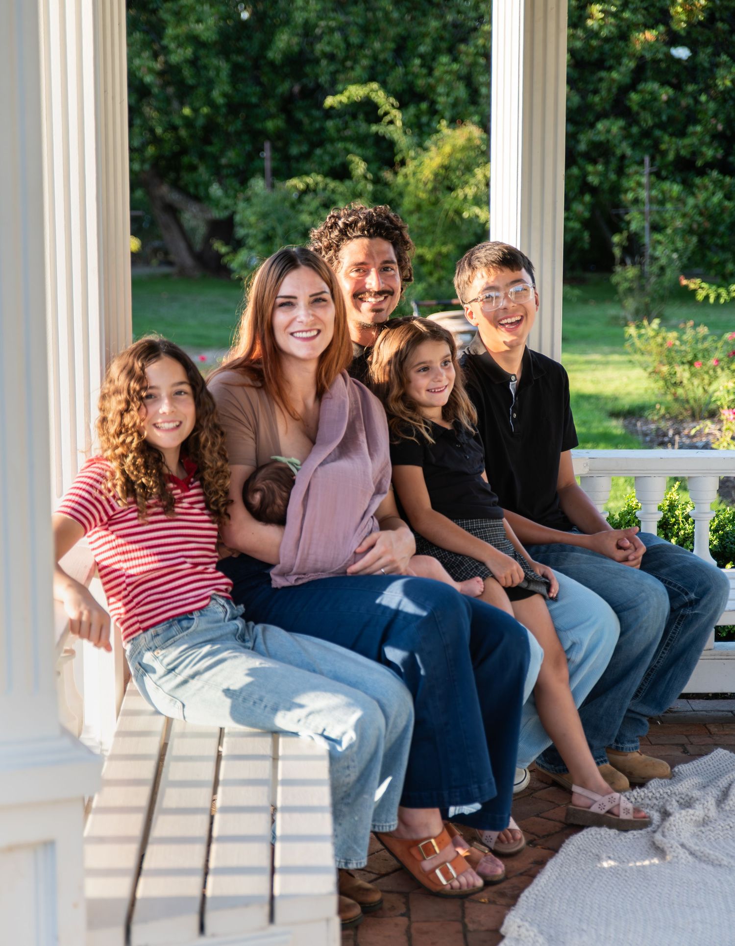 Family gathered under a gazebo on a sunny day for a family portrait photo in Salem, OR.