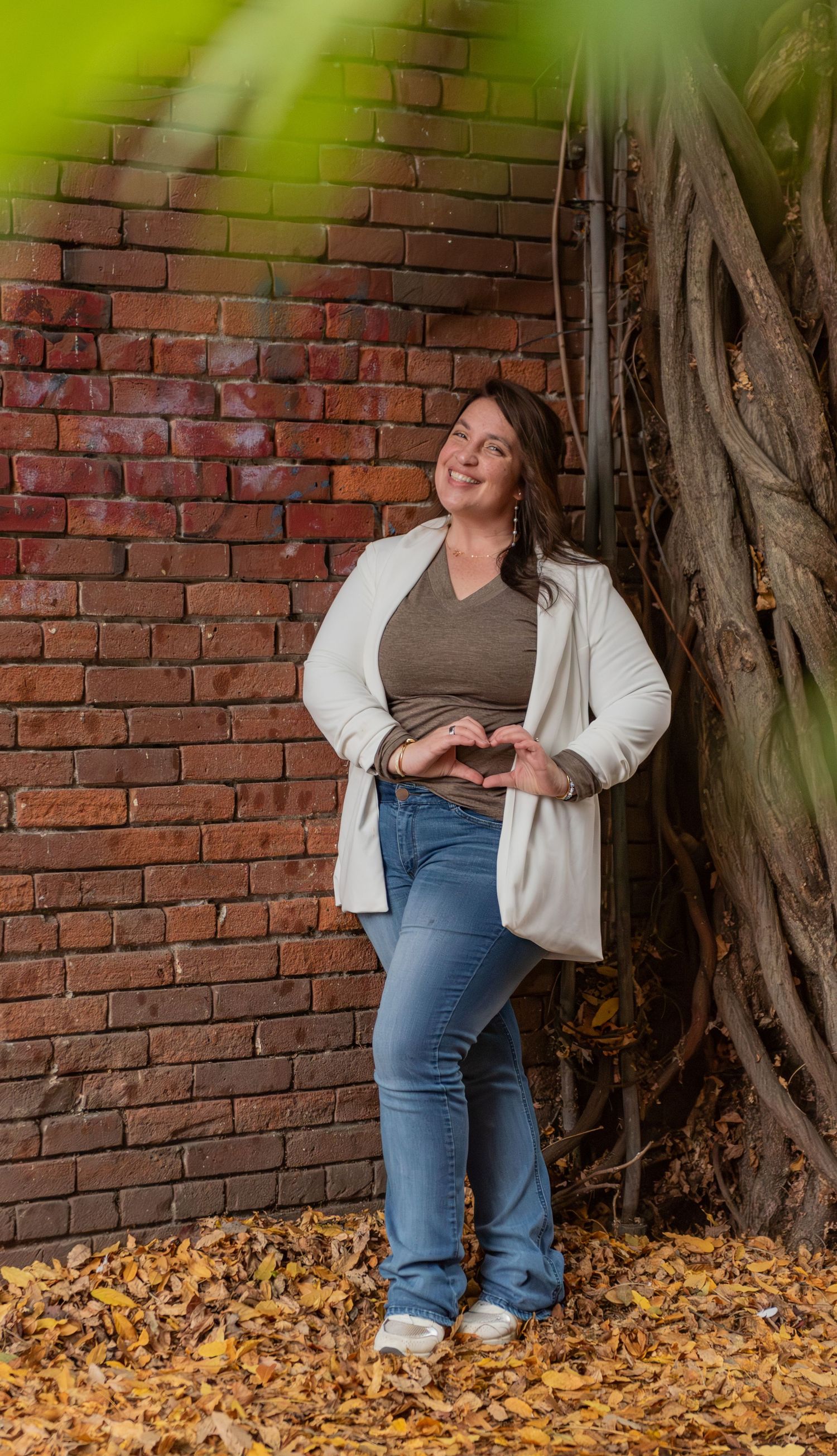 Headshot of woman on steps with red brick background, for branding images, located in Salem, OR.