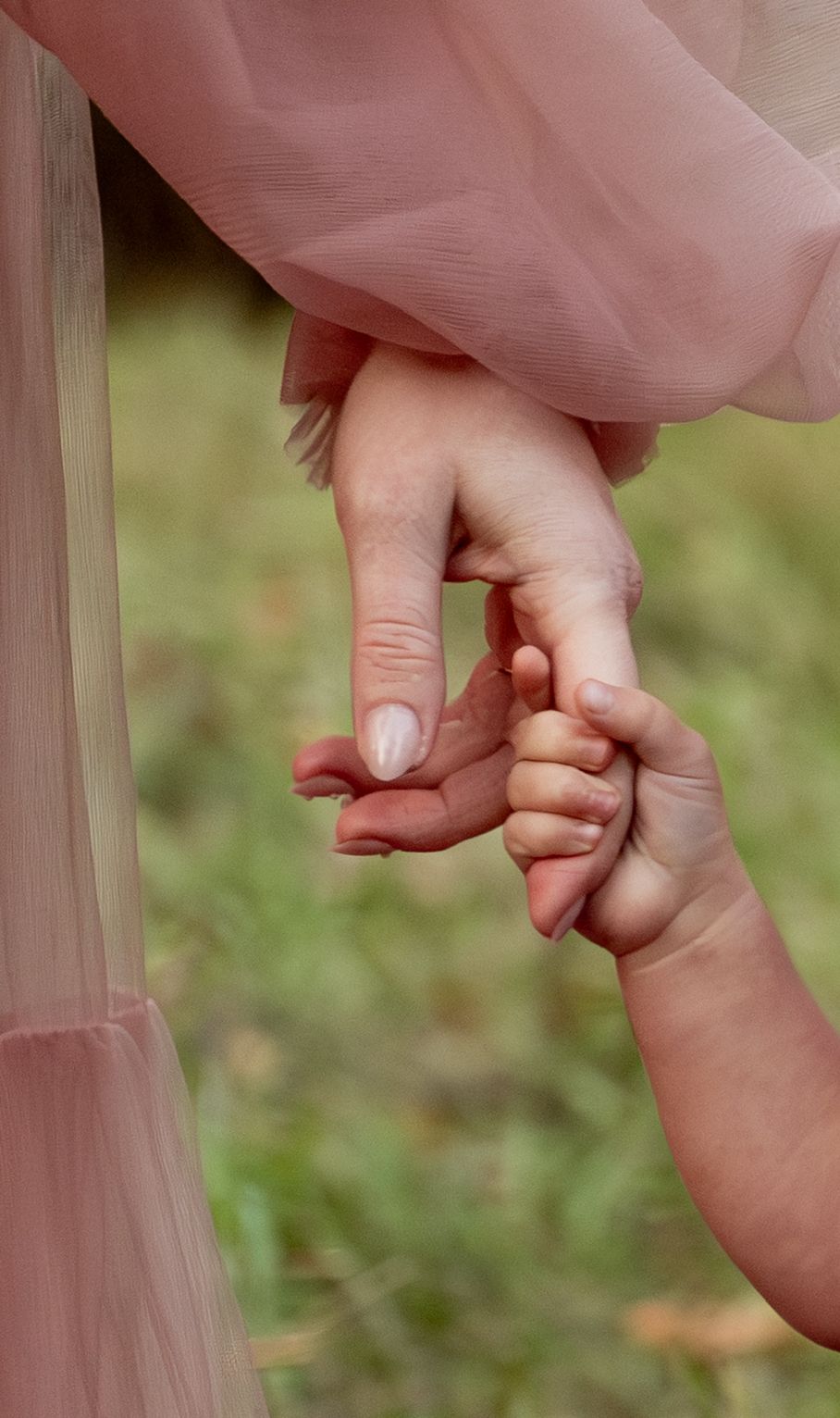 detailed image of Toddler girl holding moms hand located in an open field in Salem, OR