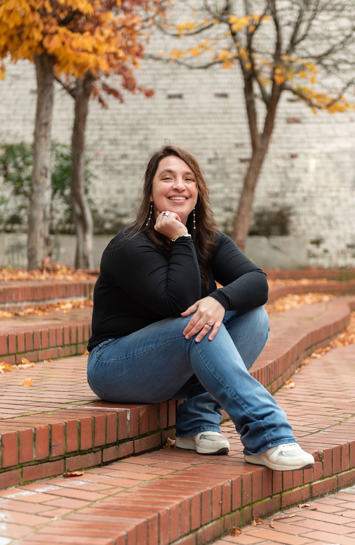 Headshot of woman on steps with red brick background, for branding images, located in Salem, OR.