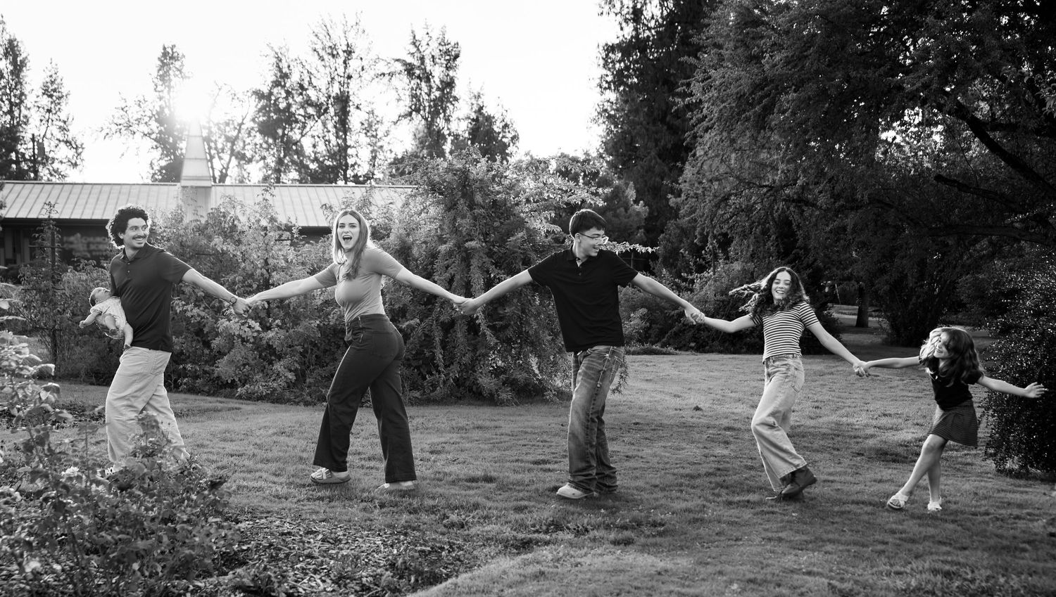 Family of six walking hand in hand in a park in Salem, OR.