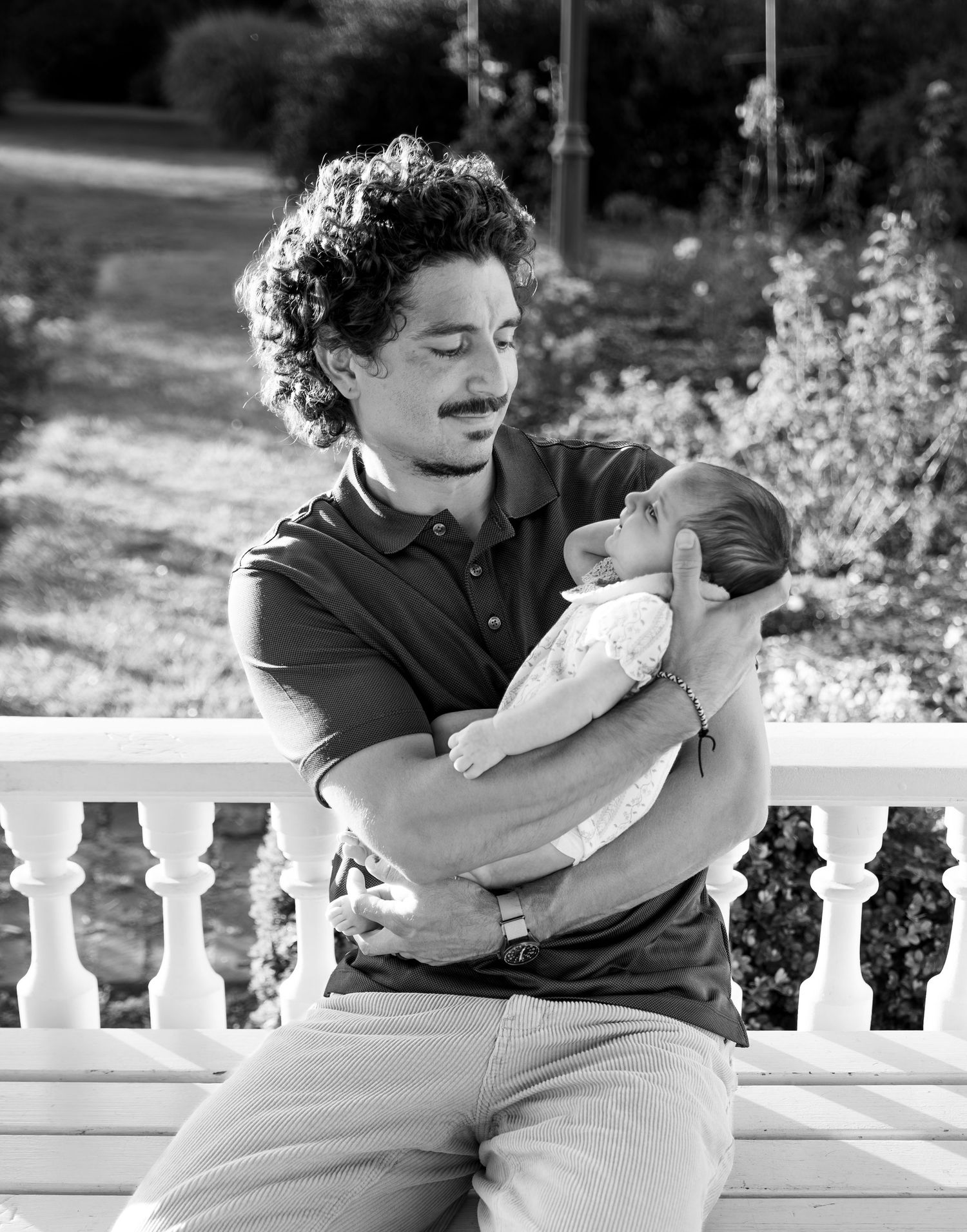 Black and white portrait of Dad holding baby with glowing natural golden hour sun. Salem, OR.