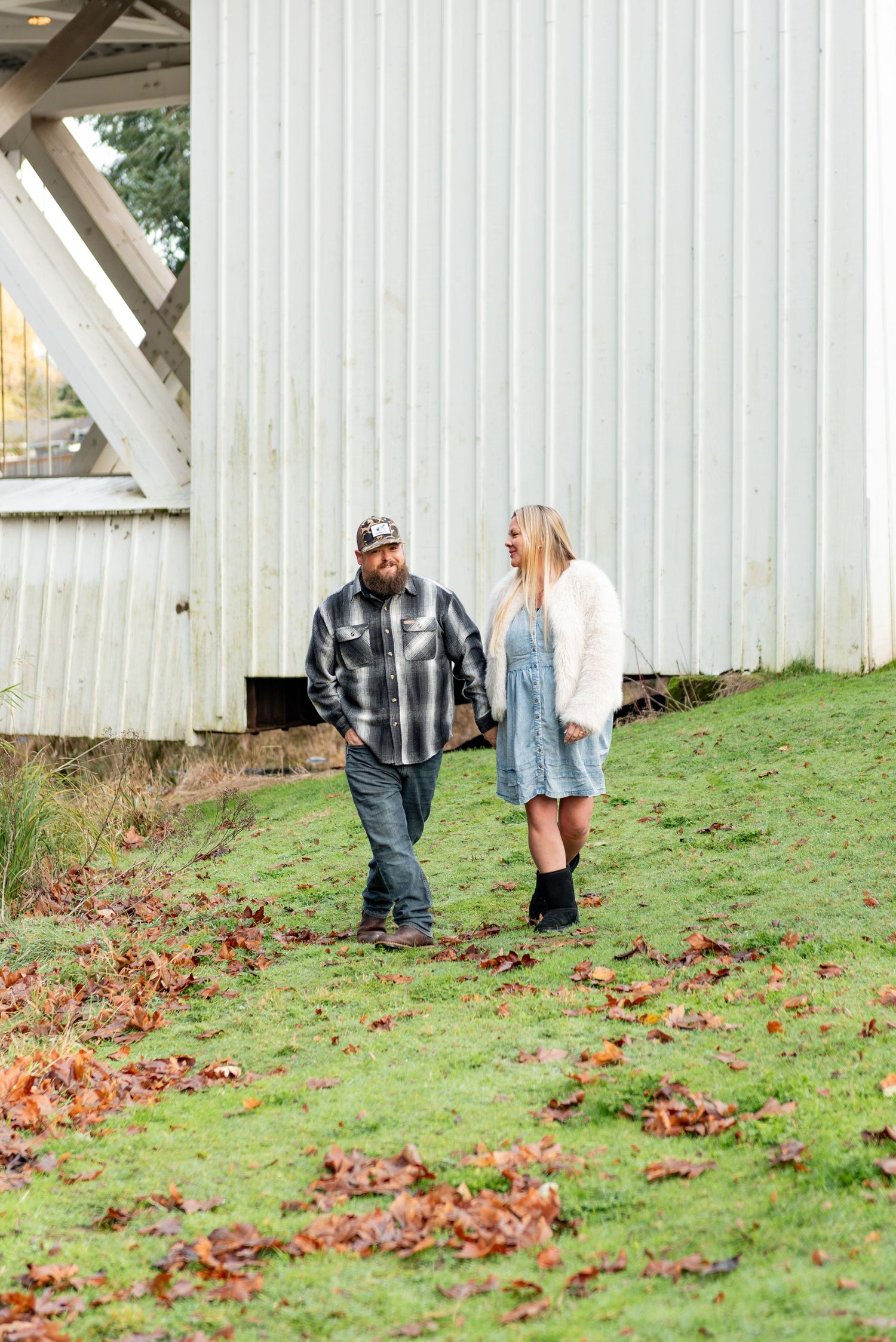 Detailed maternity image of mom and dad walking and conversating along a river in Stayton, OR