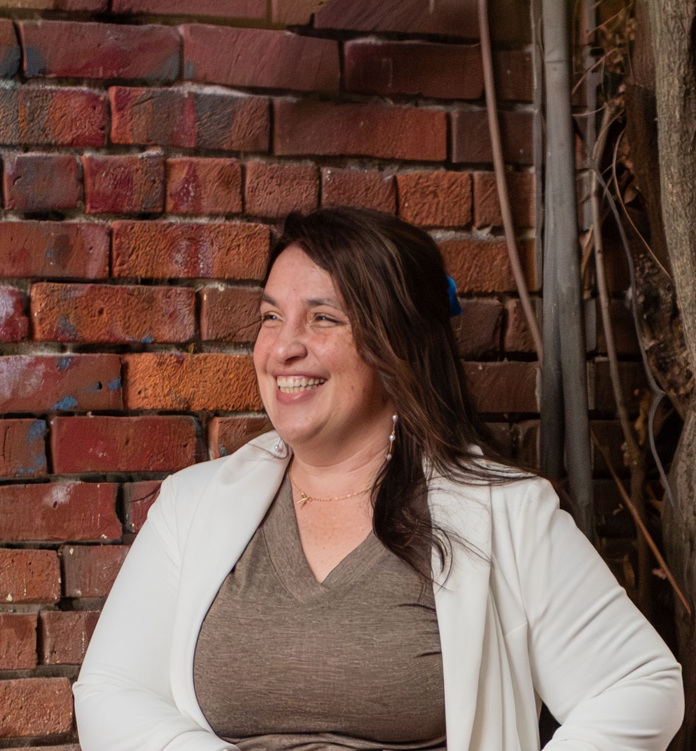 Headshot of woman on steps with red brick background, for branding images, located in Salem, OR.