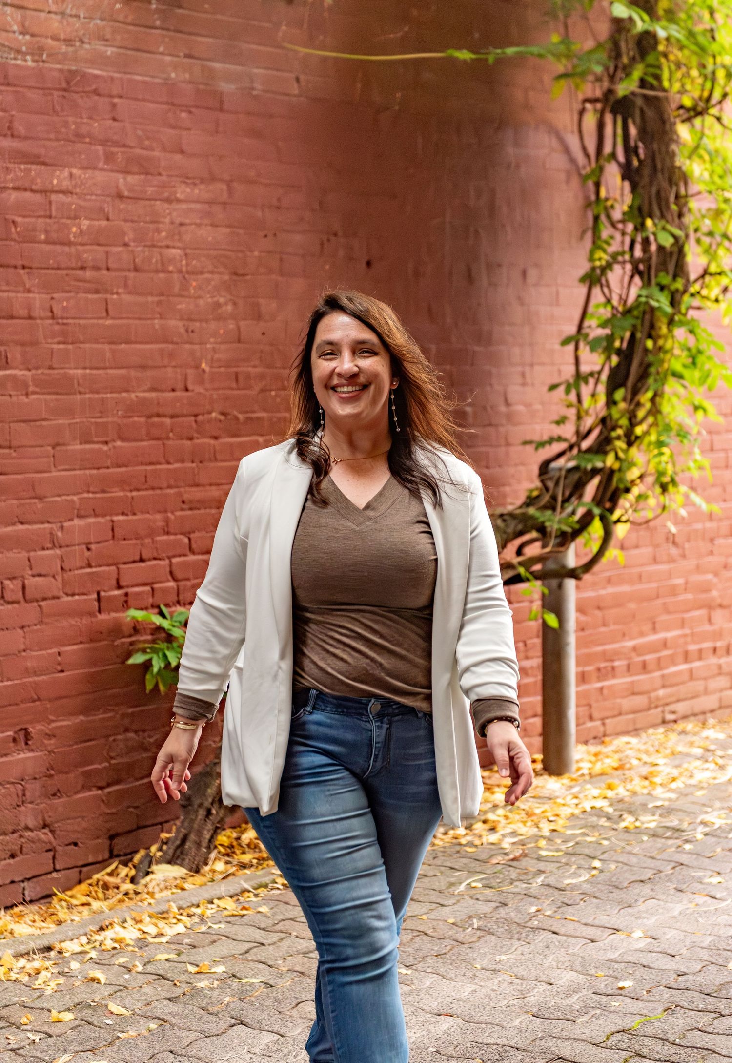 Headshot of woman on steps with red brick background, for branding images, located in Salem, OR.