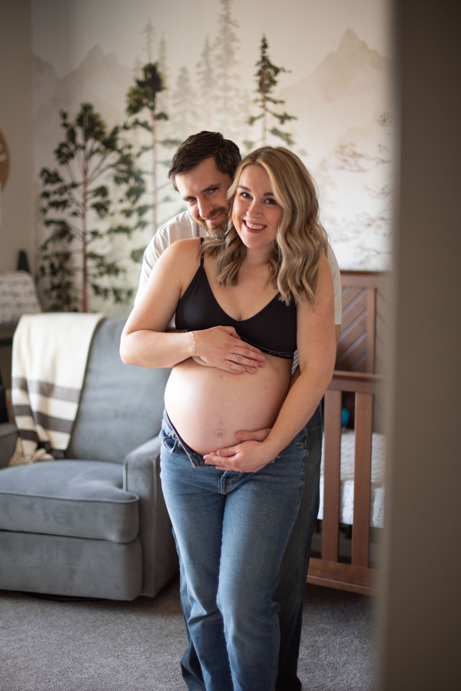 A couple embraces during a maternity photo shoot, with hands lovingly placed on the pregnant belly. Located in Salem, OR