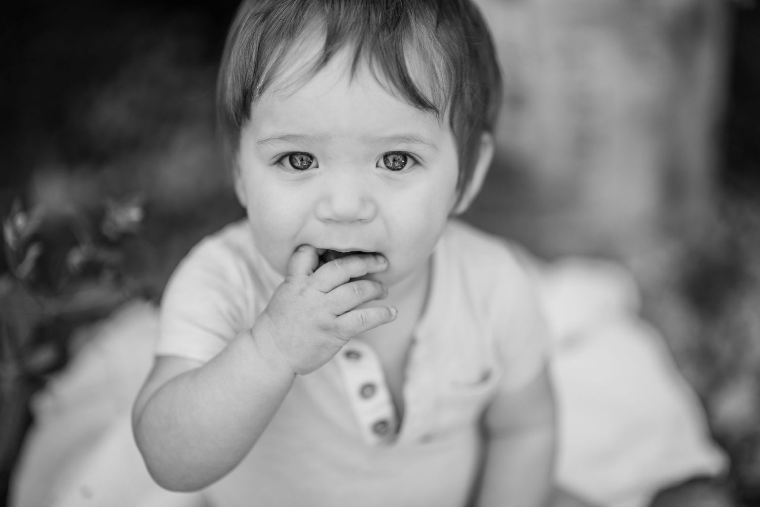 Black and white photo series of a young child making various playful facial expressions.