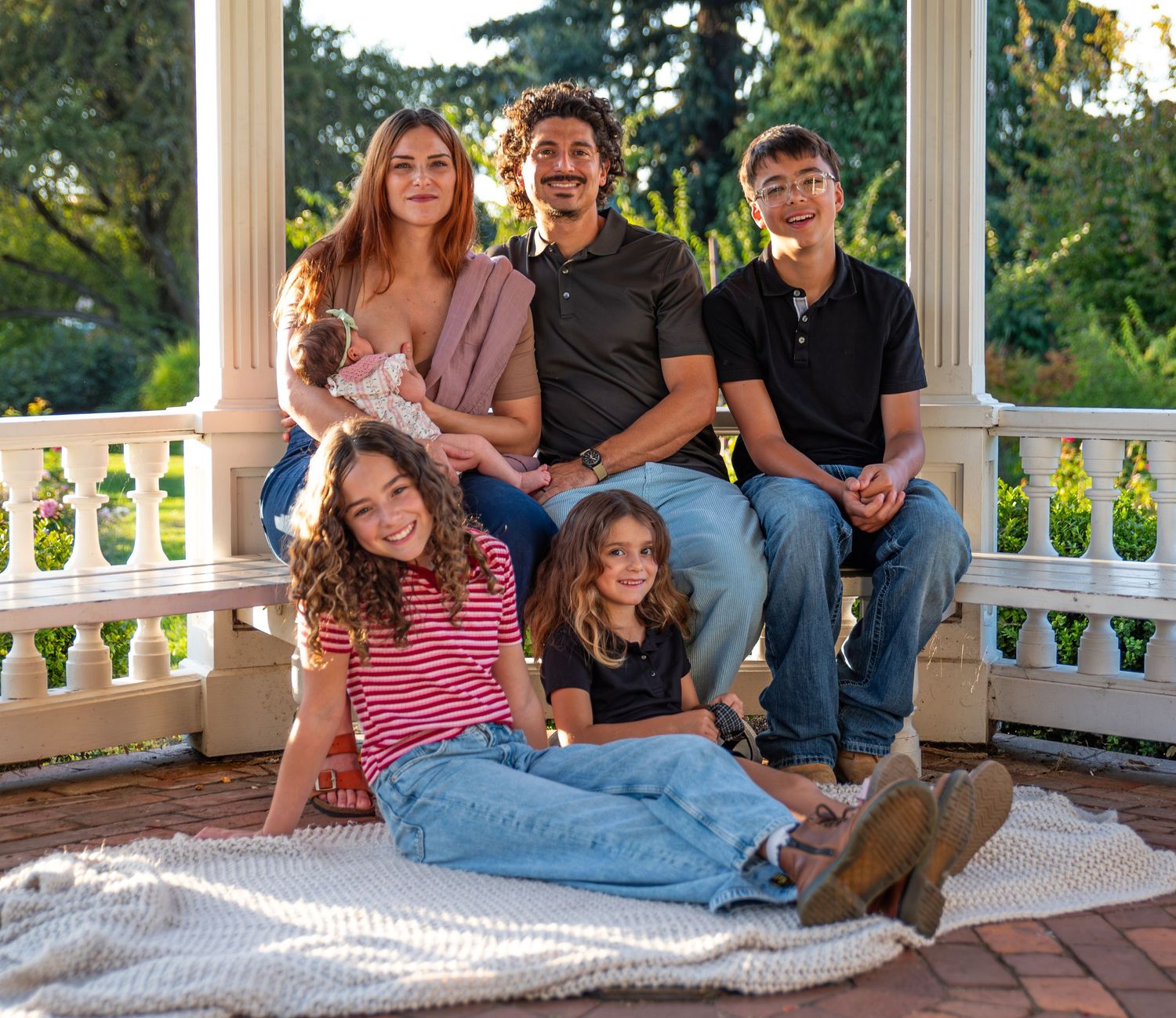 Family gathered under a gazebo on a sunny day for a family portrait photo in Salem, OR.