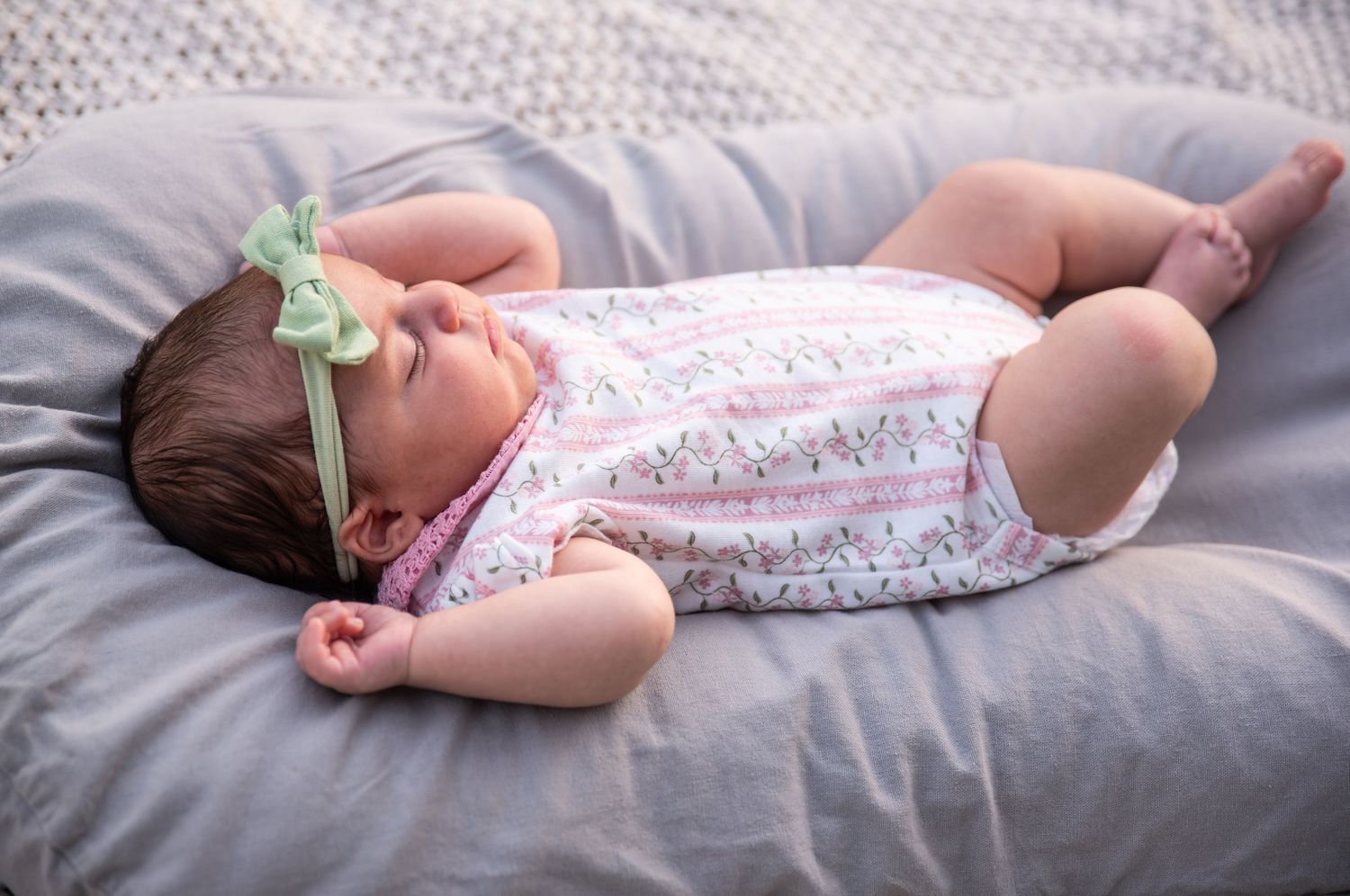 four month old baby laying in a lounger for a portrait photo with soft glowing golden hour light, Salem, OR.