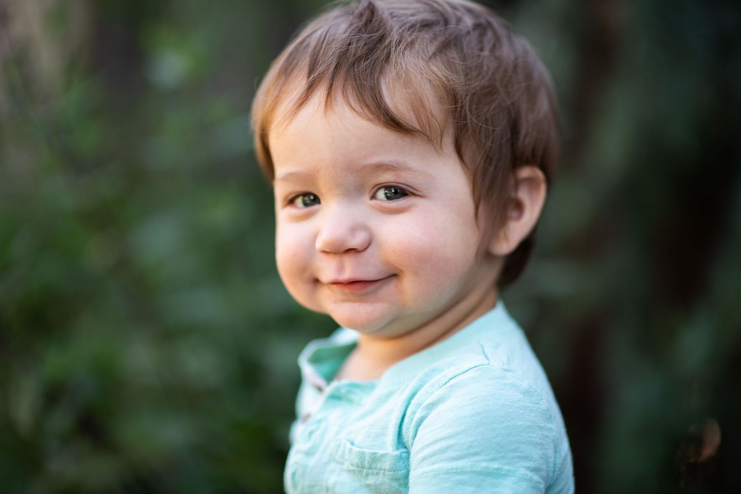 A series of four close-up photos showing a baby with a cheerful expression wearing a light blue outfit.