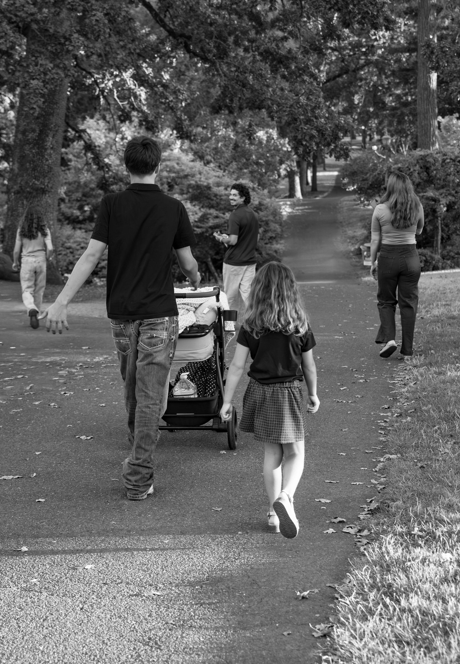 Family of six strolling through paths at bush pasture park in Salem, OR Black and white photo.