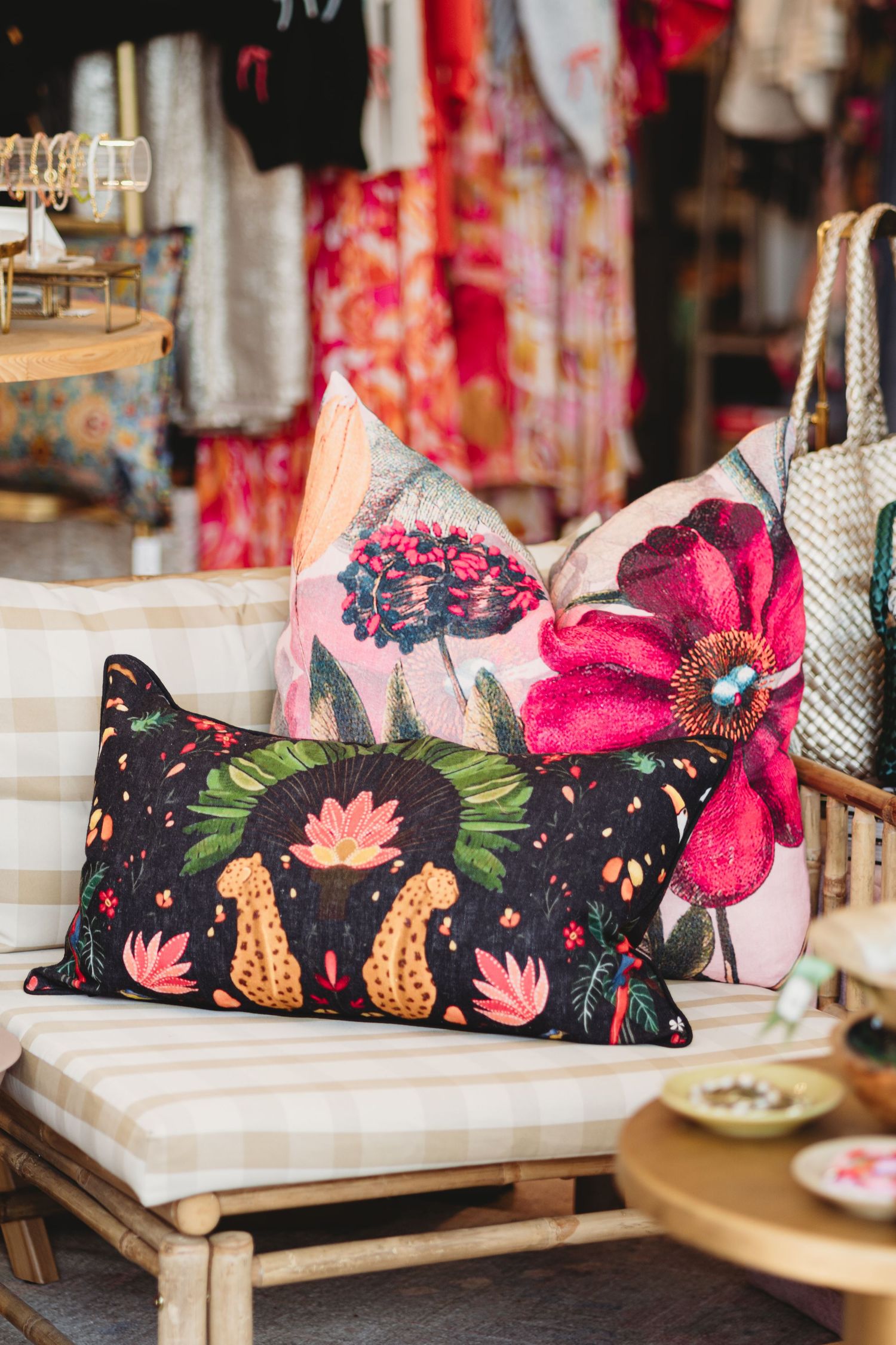 Two differently sized pillows displayed on a bamboo chair showcase two different fabric prints for a brand.