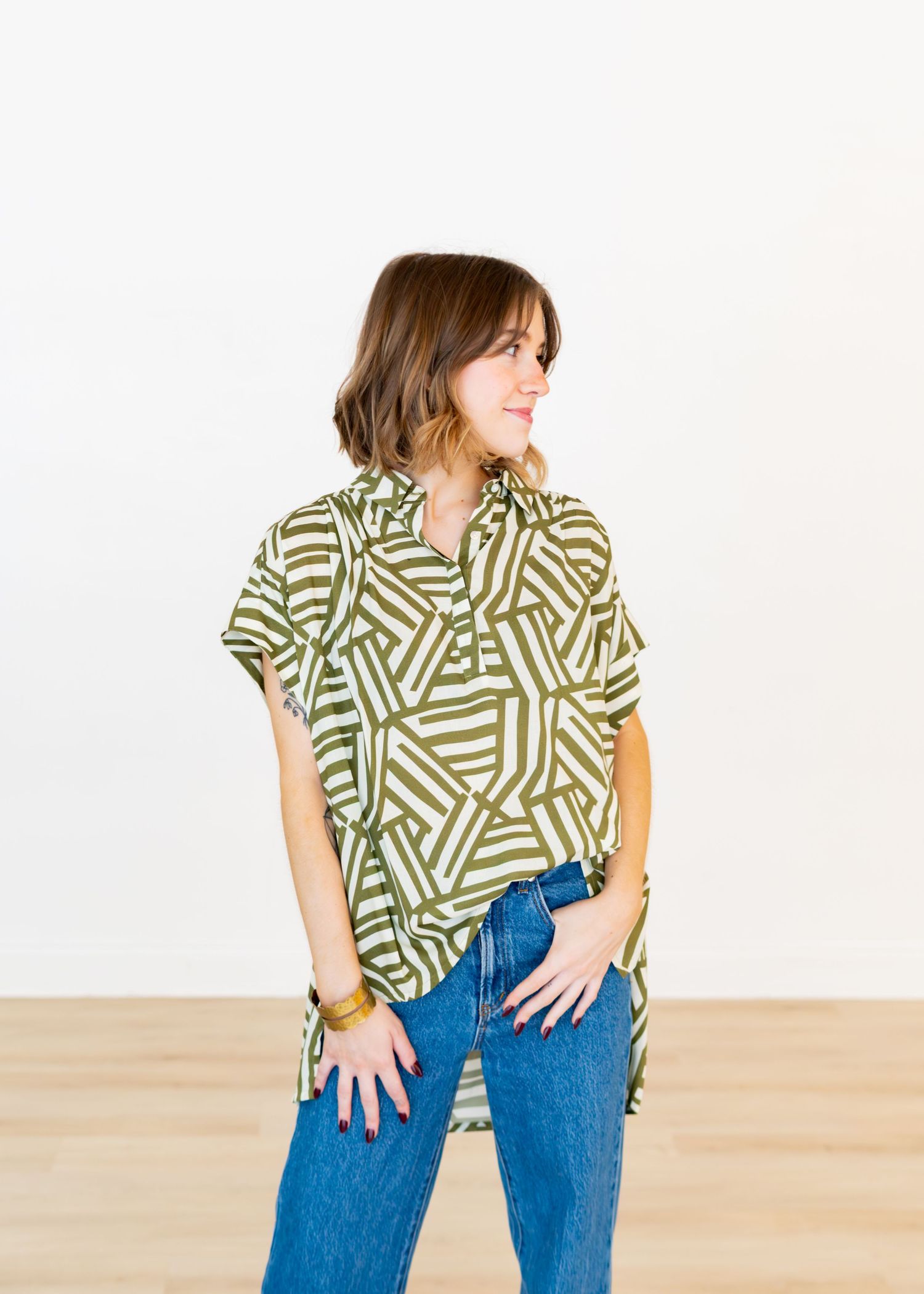 New clothing line photoshoot showcasing a woman wearing a shirt or top posing in a studio.