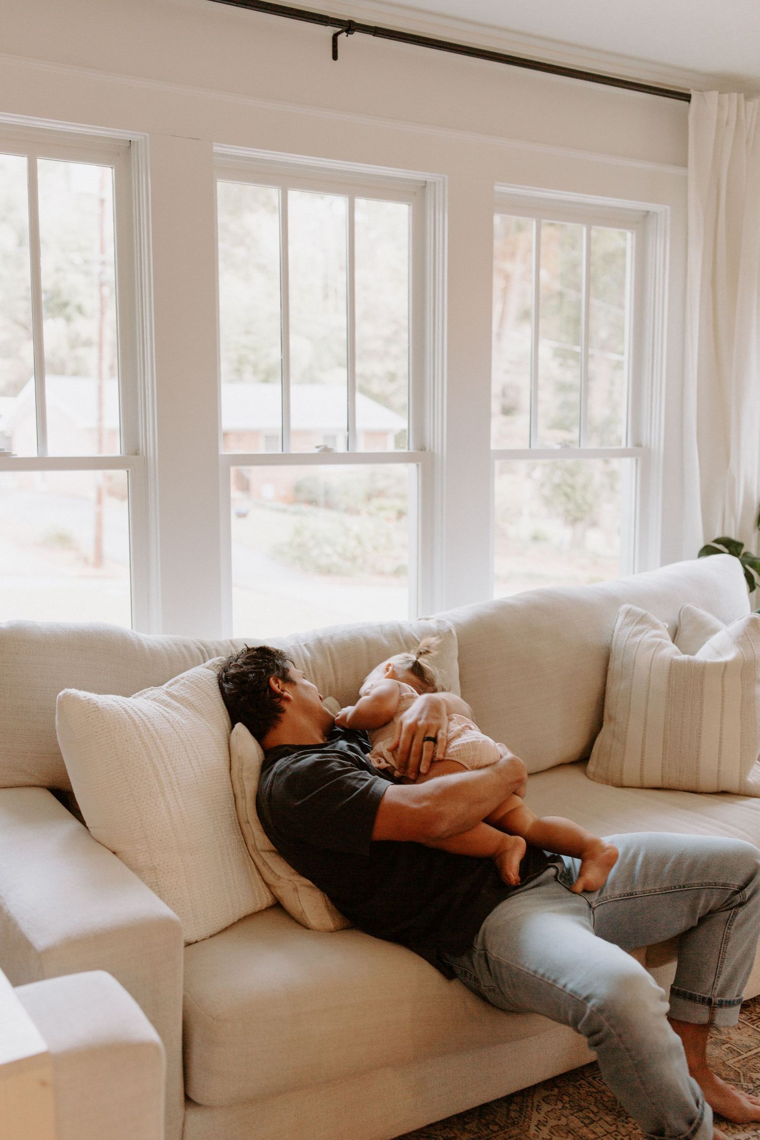 Family lounging together on a comfortable white sofa in a modern living room.