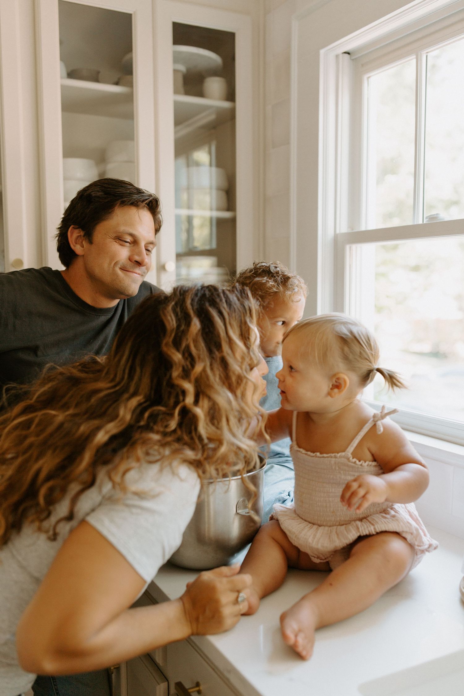 Sweet family moment while baking together in sunlit kitchen.