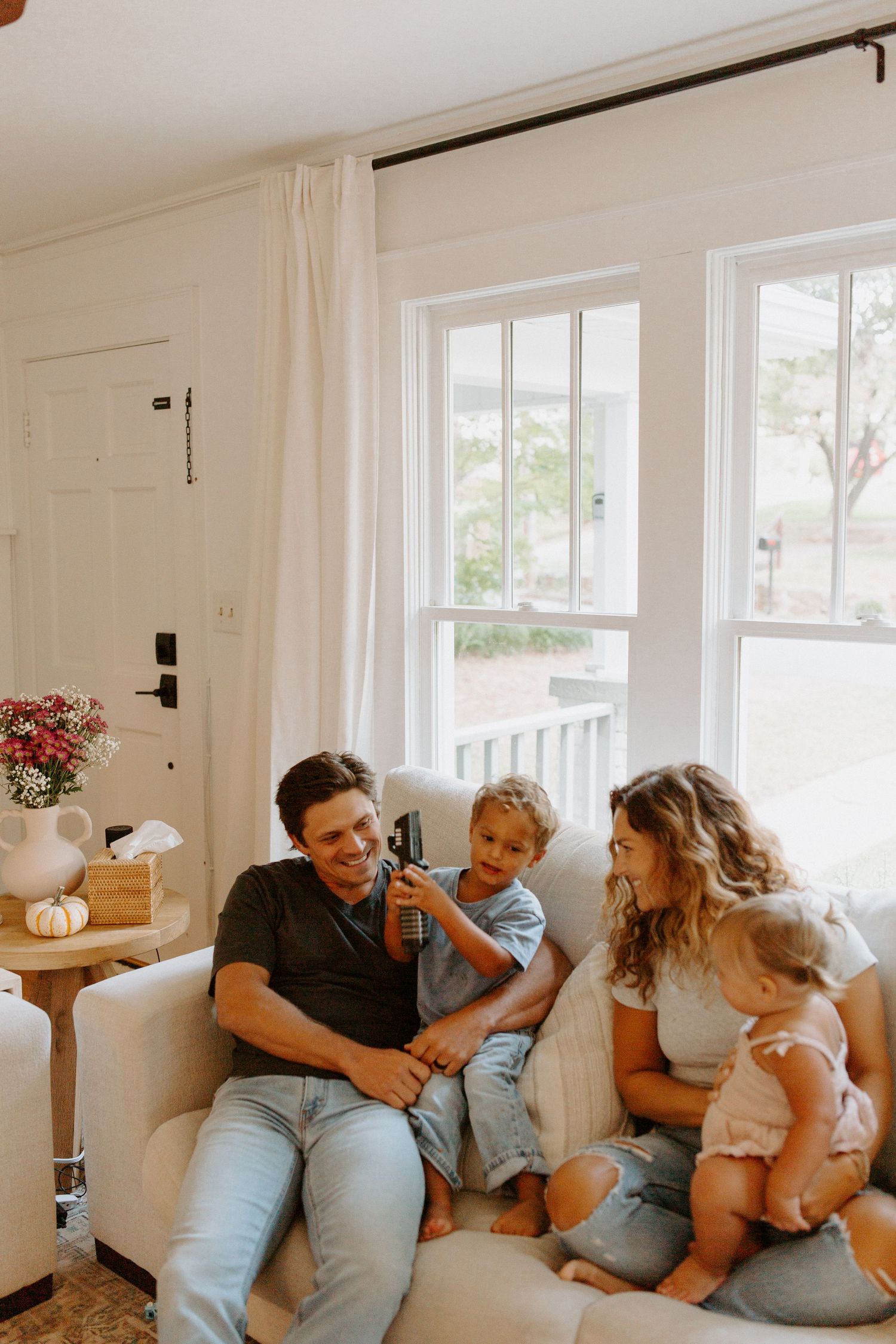 Candid family lifestyle photos showing playful interactions in bright modern living space.