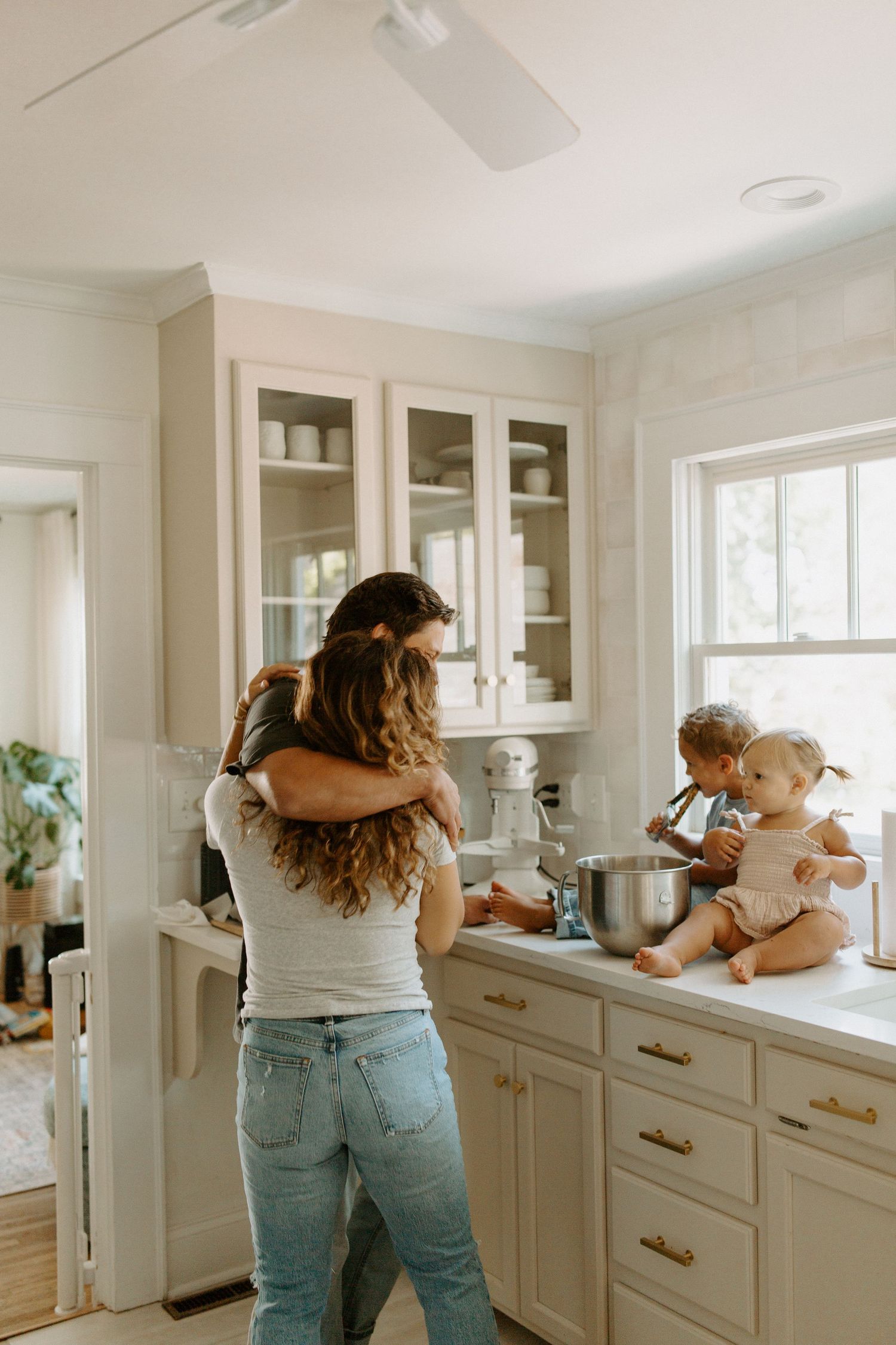 Family spending quality time together in their bright modern kitchen with white cabinetry.