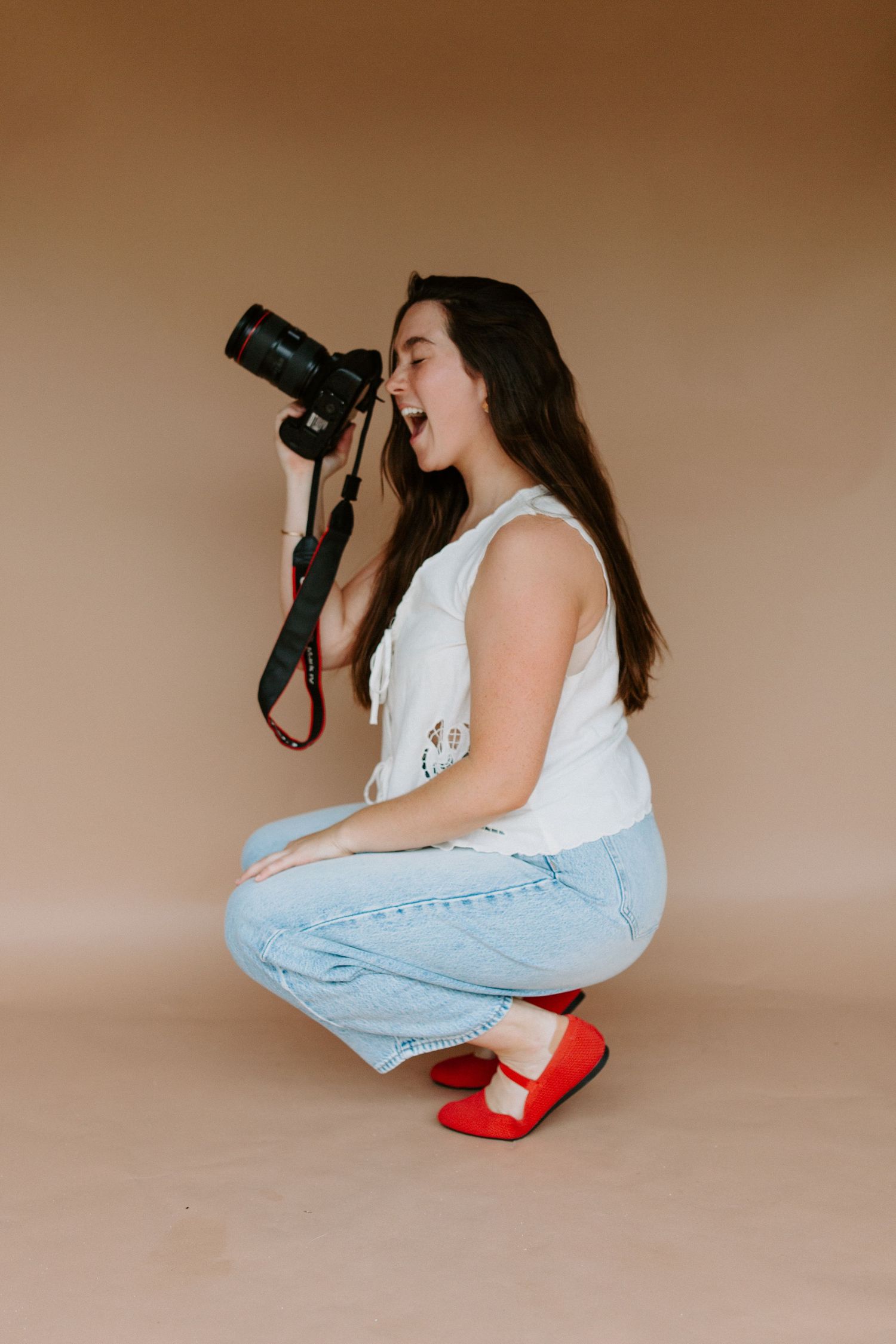 Photographer demonstrates various shooting positions with professional camera.