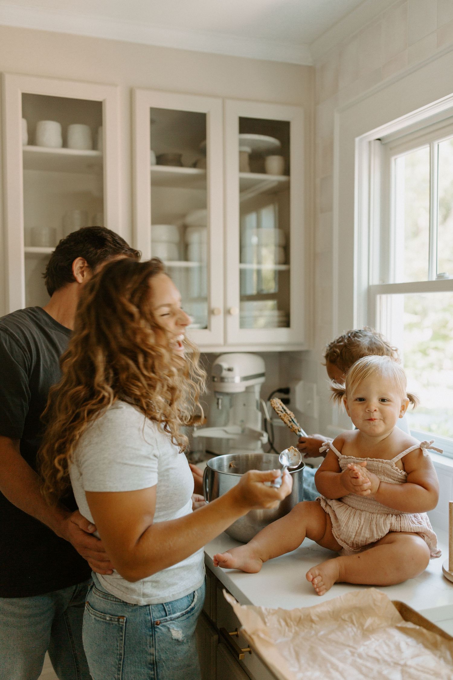 Sweet family bonding moments while baking together in a sunlit white kitchen.