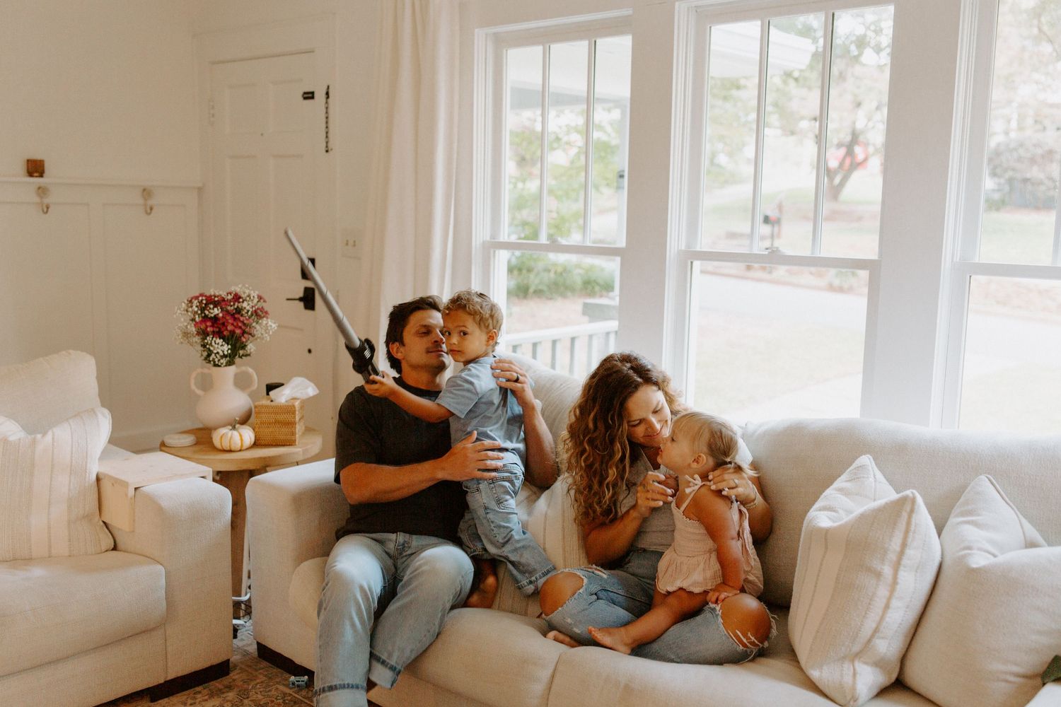 Intimate family bonding moments photographed in series on white couch with window backdrop.