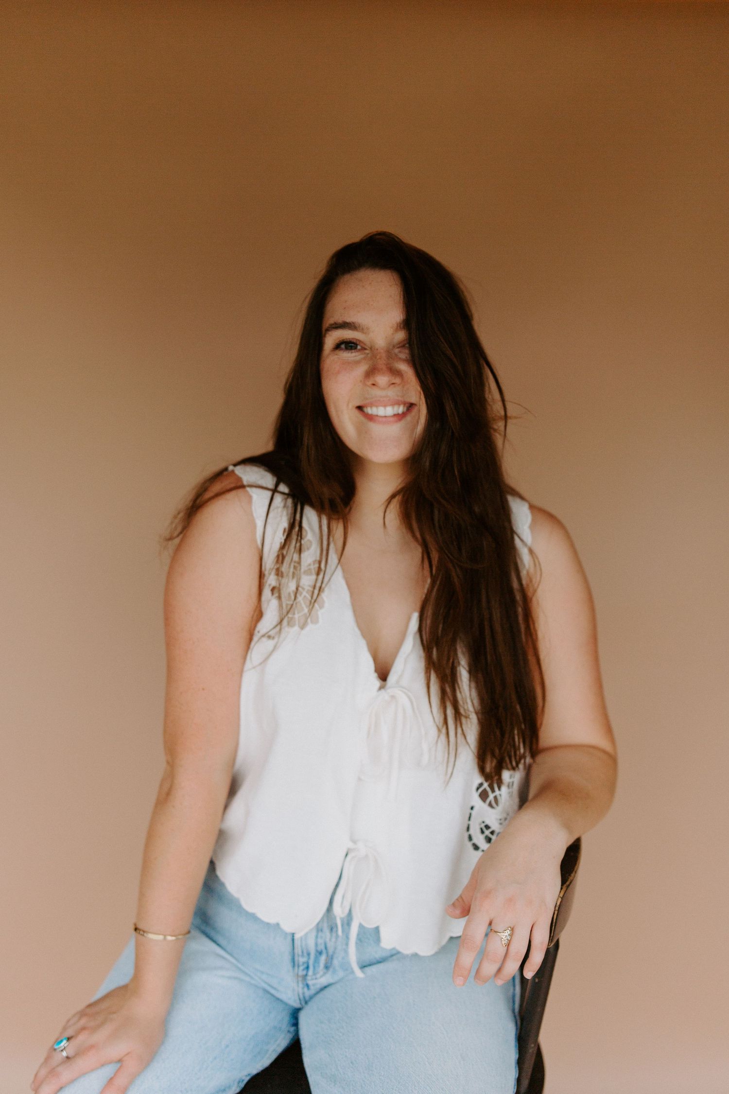 Casual studio portrait session featuring white shirt and light denim styling.