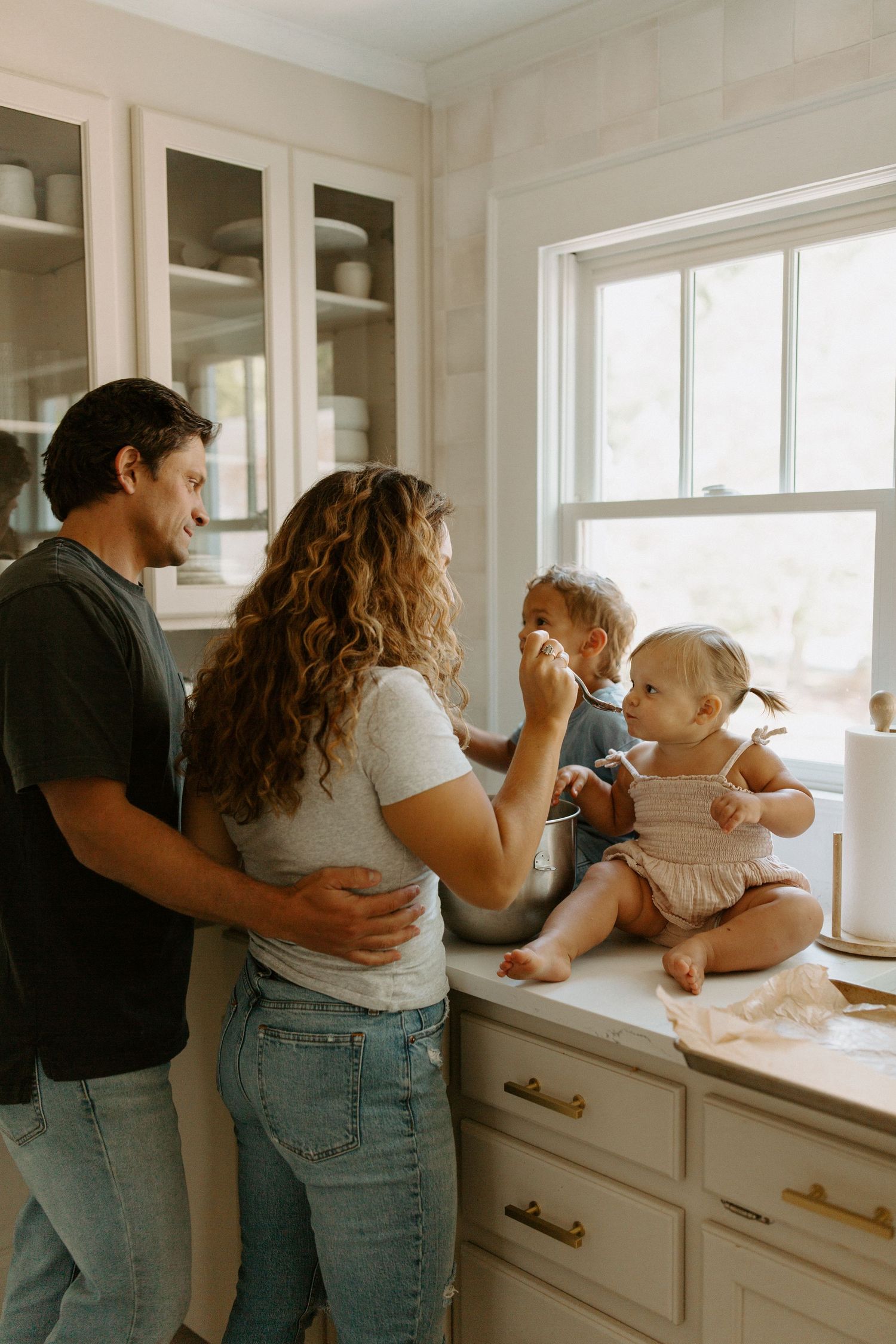 Family sharing sweet moments while baking together in white modern kitchen.