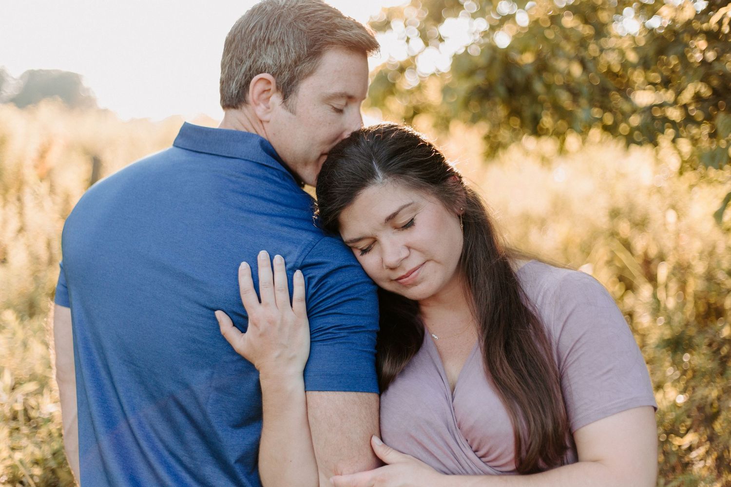 Couple embracing during golden hour in outdoor setting.