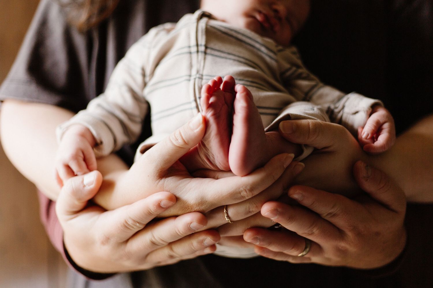 Close-up detail of tiny newborn fingers and hands.