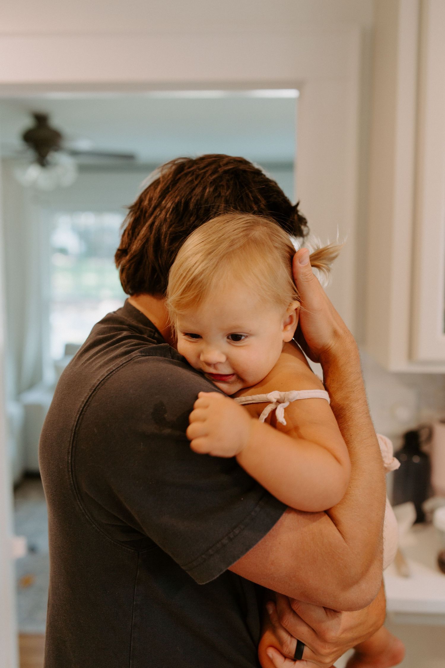 A tender moment shared in a bright, modern kitchen setting.