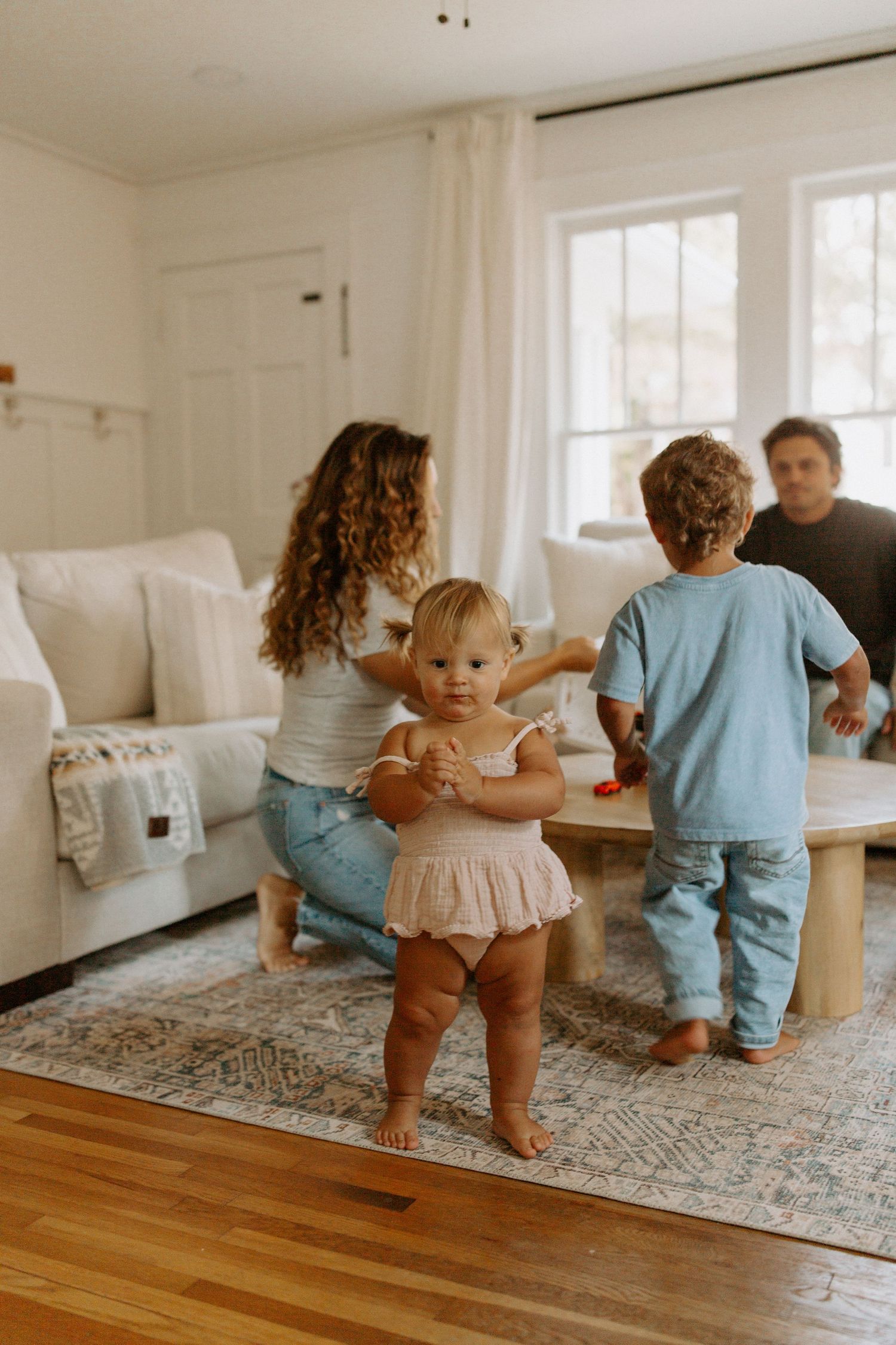 Casual family moment around coffee table in bright modern living room.