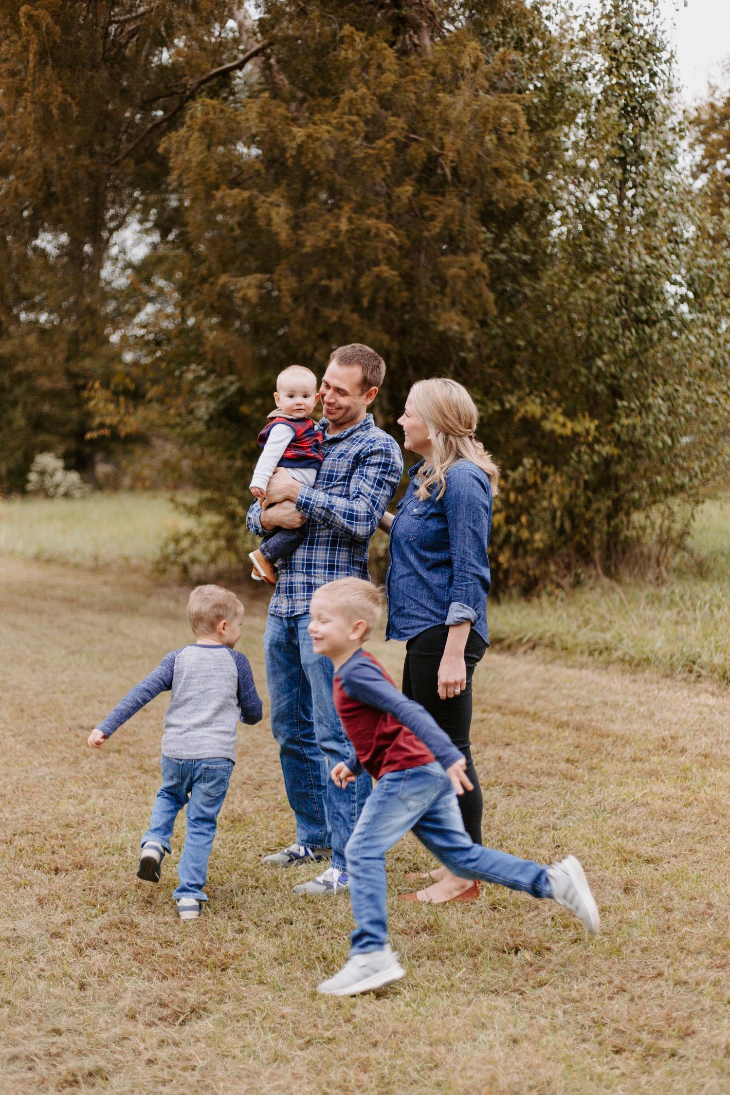 Candid family moment showing playful interaction in an autumn field.