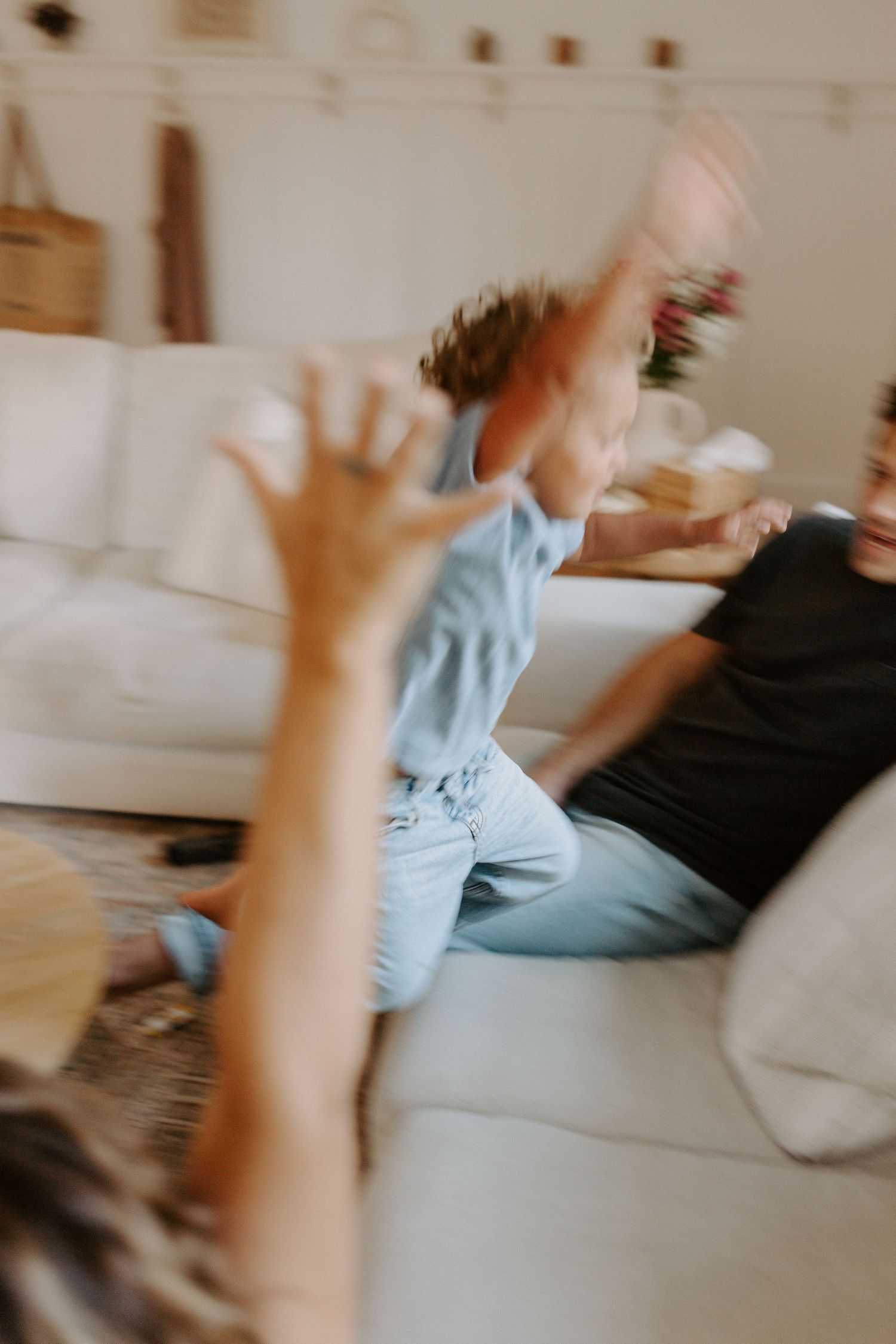 Motion-blurred sequence of active play and movement on white sectional sofa.