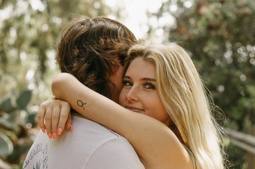 Romantic outdoor portrait of couple embracing in golden sunlight.