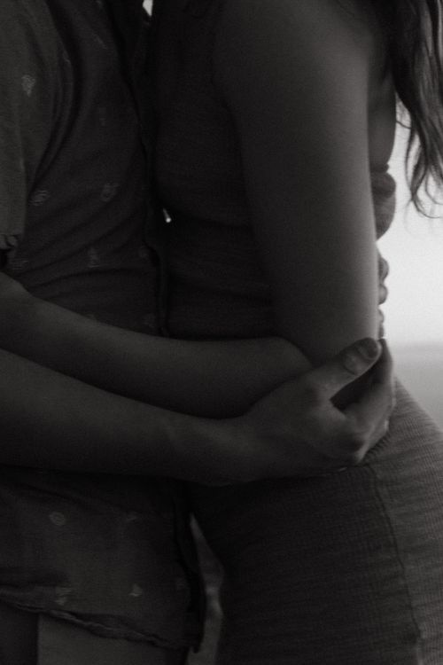 Artistic black and white close-up of couple in intimate embrace.