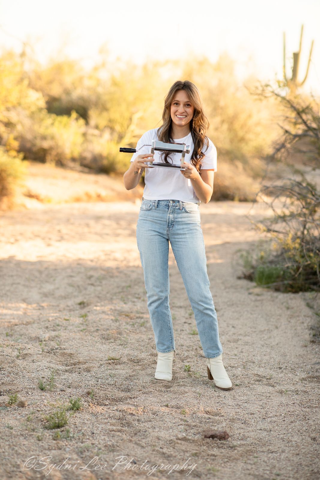 A series of casual fashion photos showing light denim jeans and white sneakers against a desert backdrop.