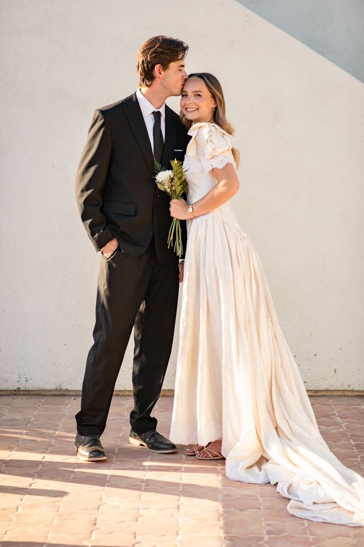 Wedding couple poses on terracotta tiles in natural sunlight at Desert Studio AZ.
