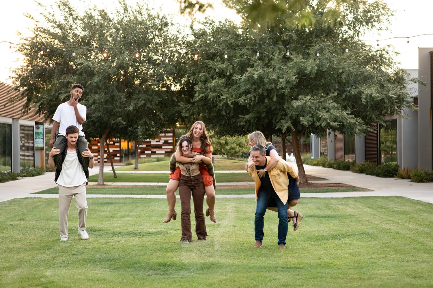Group of people walking and playing on green grass path during outdoor photoshoot at The Grove Church in Chandler, Arizona.