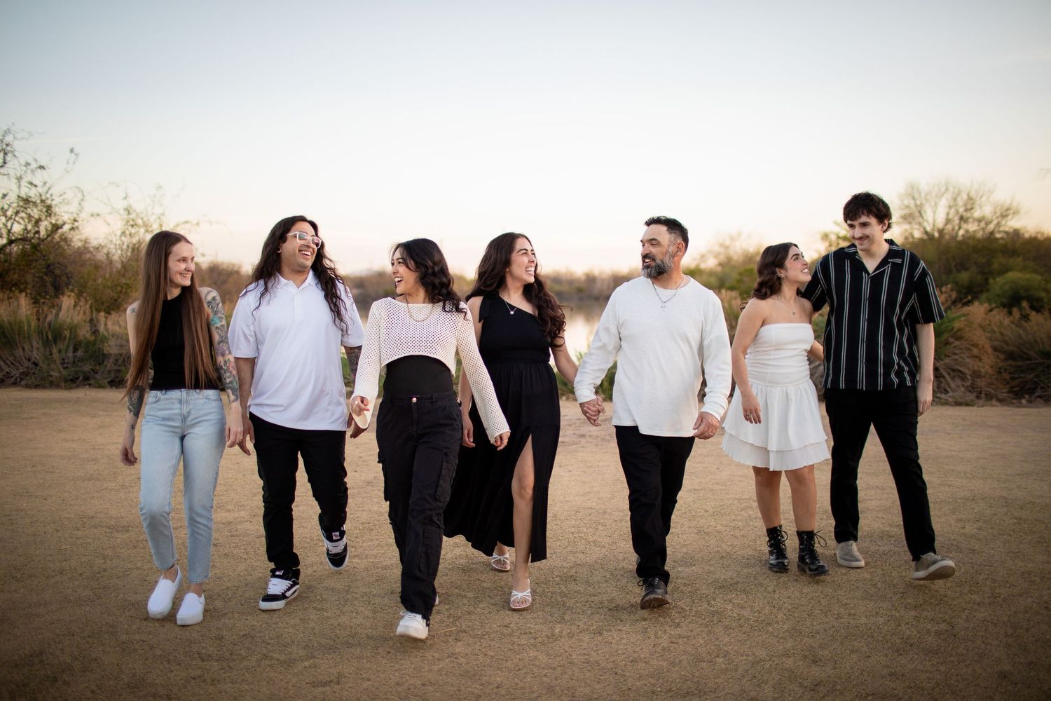 Group of friends walking together in casual attire shown from waist down against sunset backdrop.