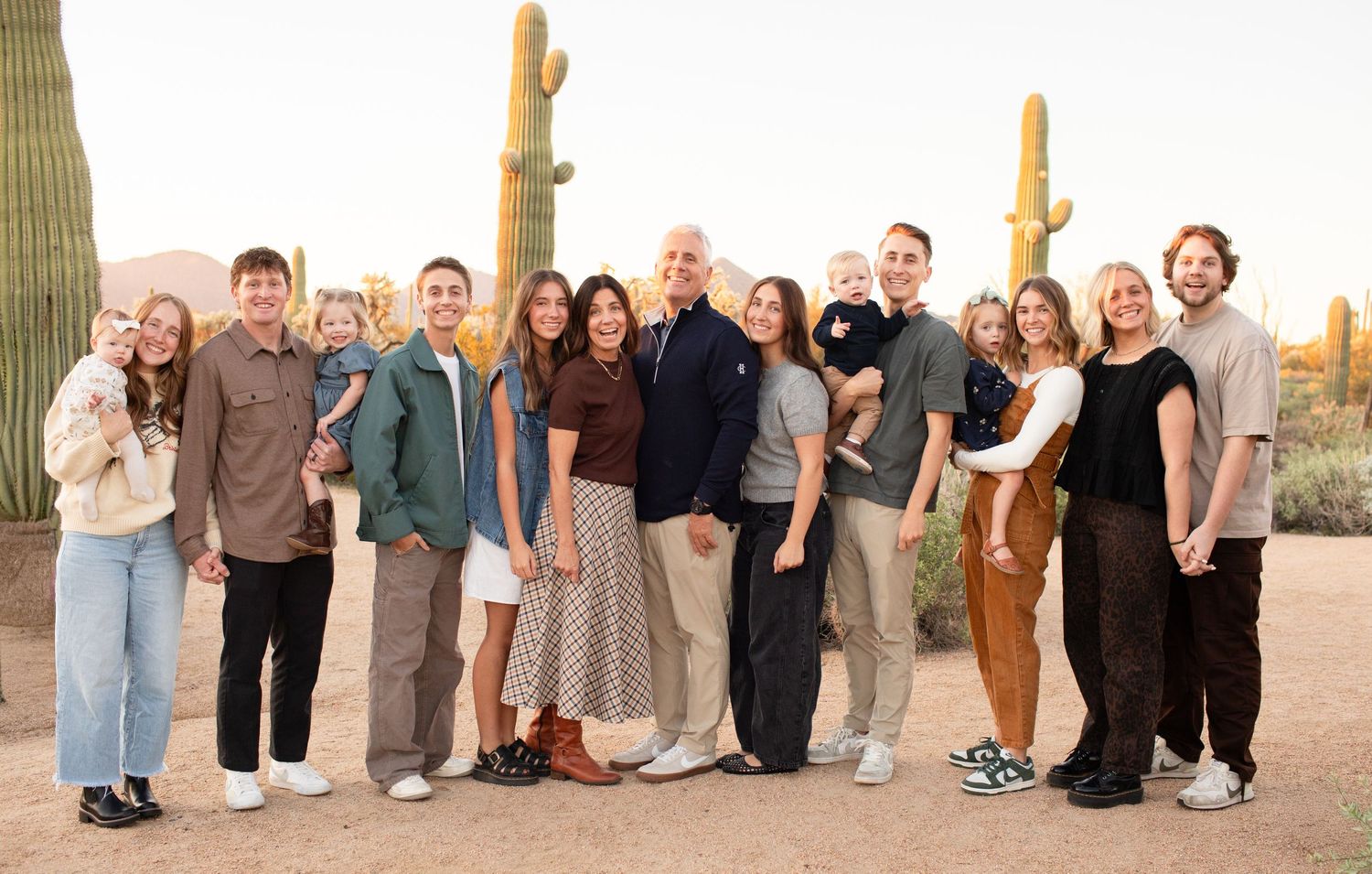 Large group photo with people lined up against desert background with cacti on the Merkle Trail at Usery Pass in Arizona.