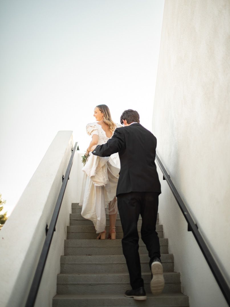Wedding sequence showing couple ascending white stairs together.
