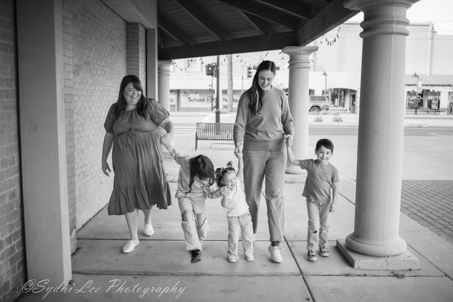 A black and white photograph of a family walking together in Downtown Mesa, Arizona.