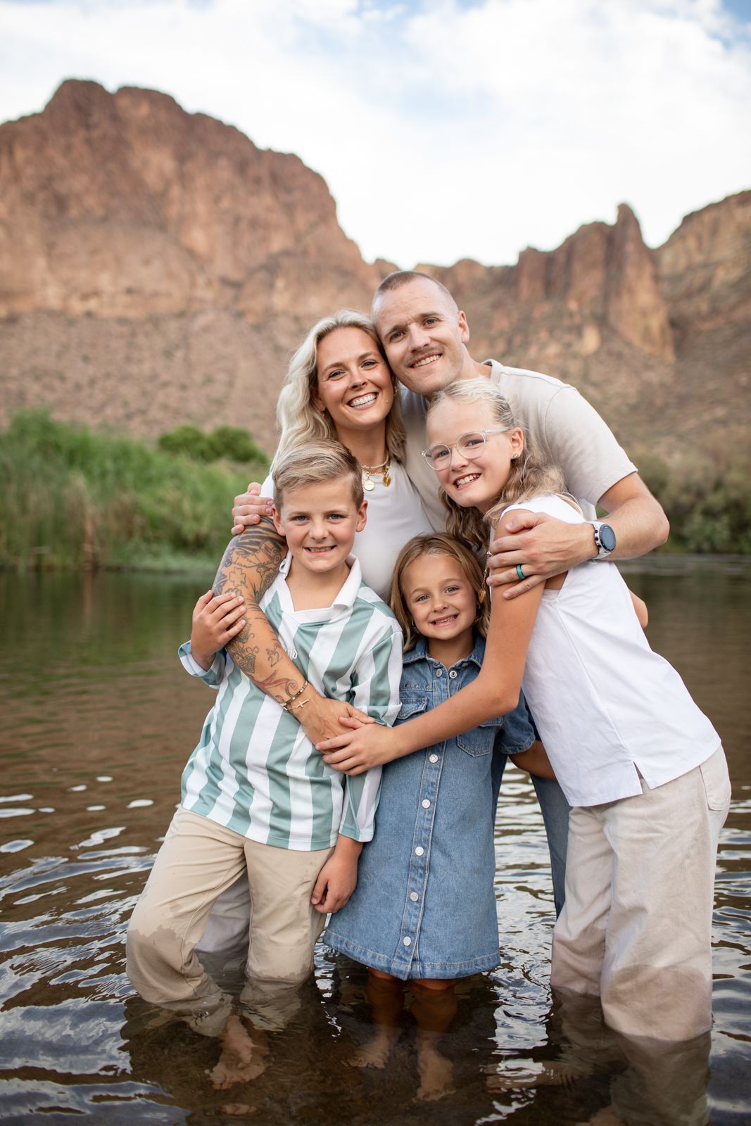 Happy family moment captured in knee-deep water with majestic canyon walls in the background at Water Users recreational area.