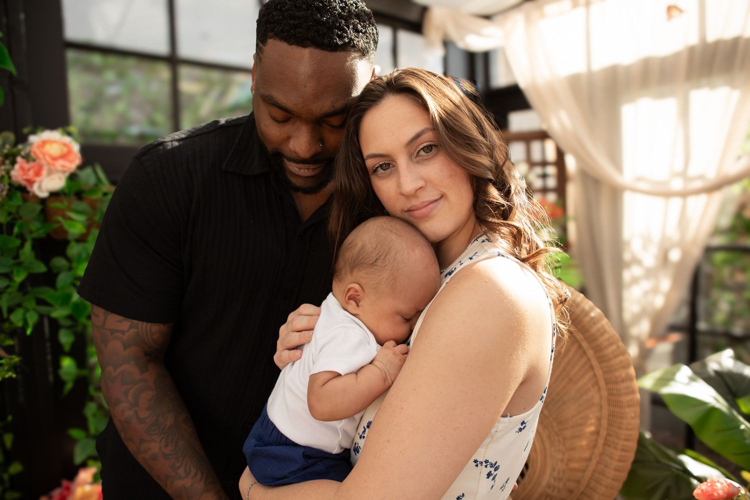 A tender family moment captured in warm indoor lighting with soft shadows at The Moody Greenhouse in Mesa, Arizona.